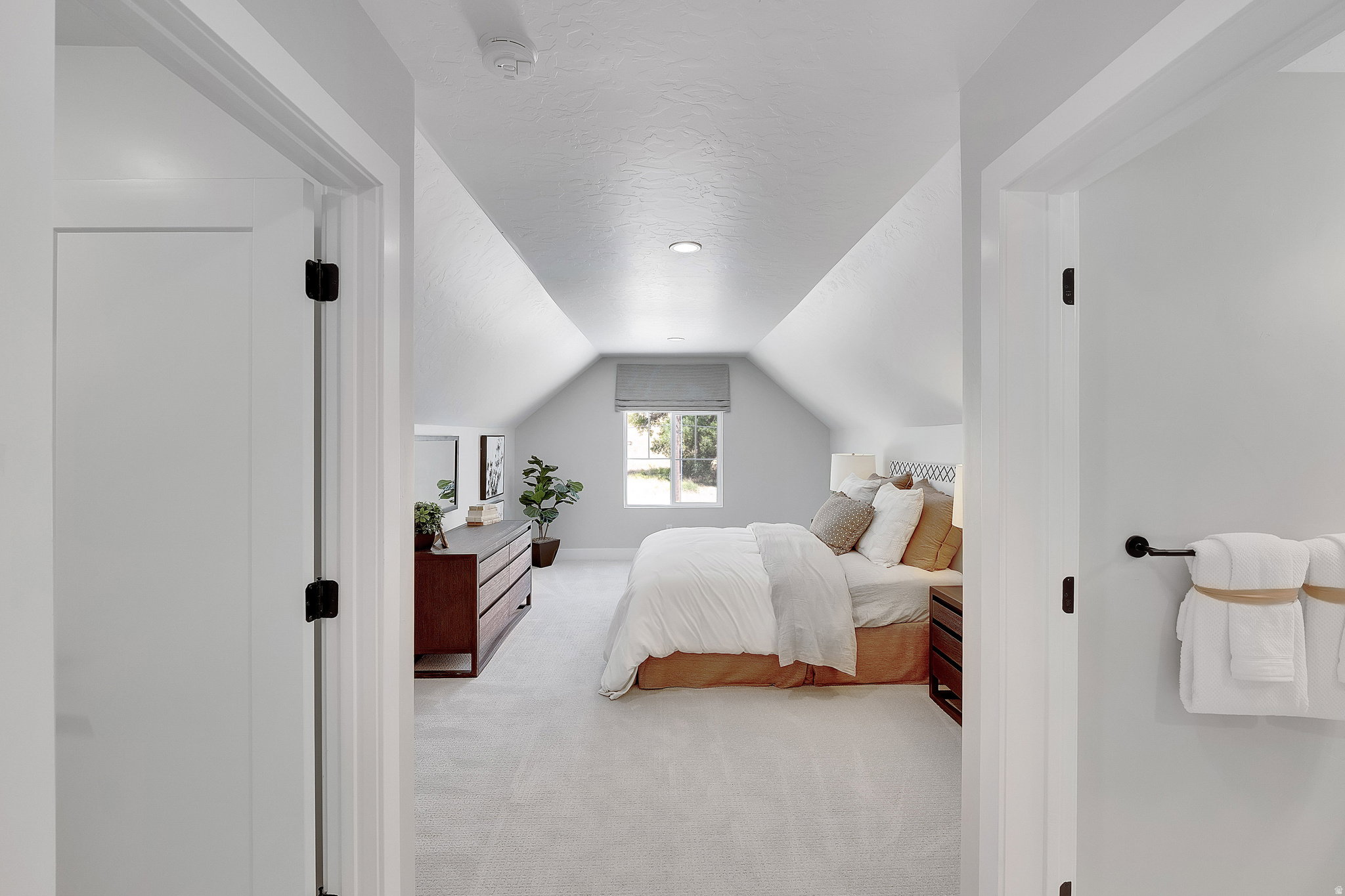 Attic bedroom featuring pitched ceilings, recessed lighting, a window with a roller shade, and light-toned carpeting. This is not the actual home being built but a representation of the features available in this home. Colors and finishes may differ from