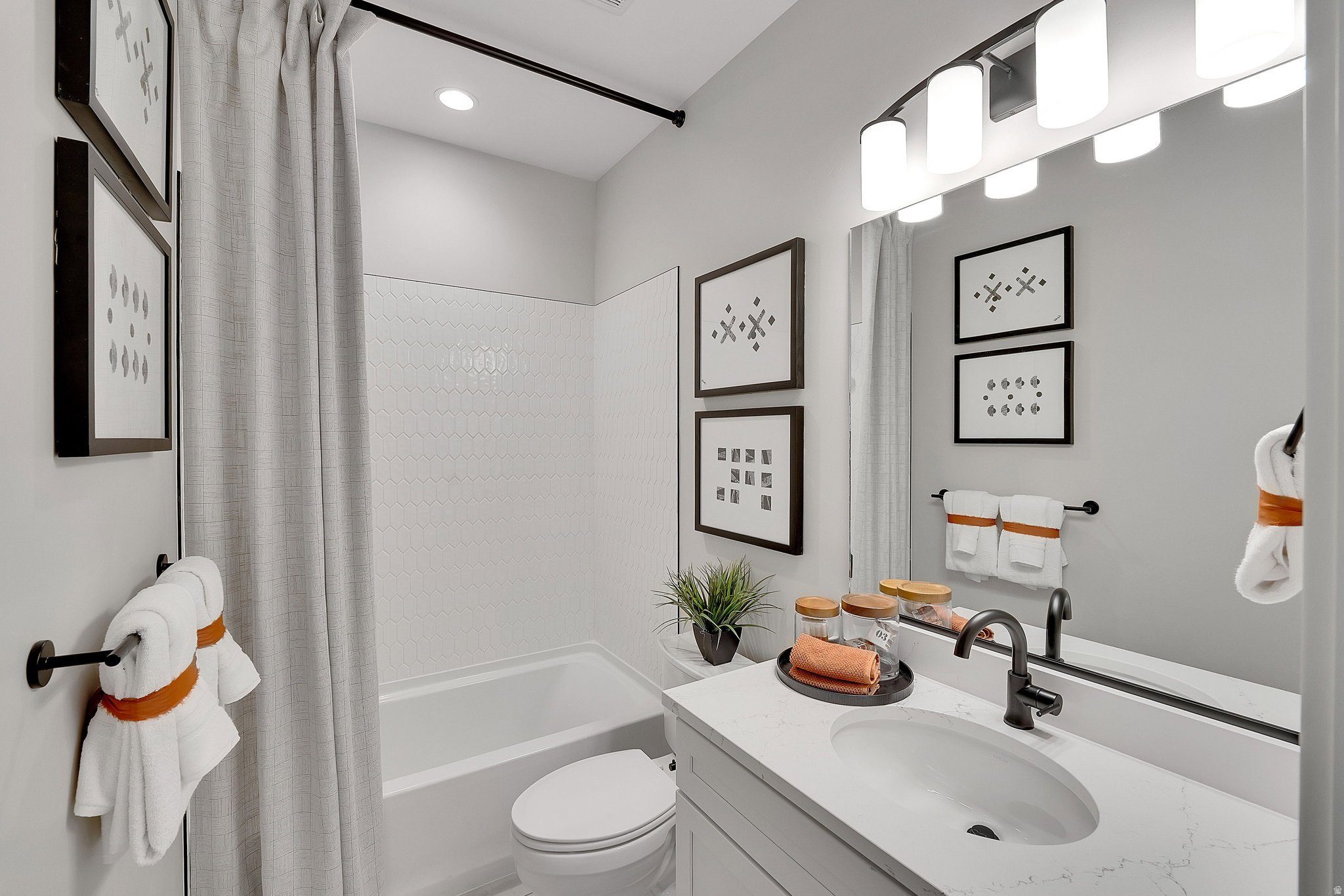 Bathroom featuring a tub and shower combination with white hexagonal tile surround. This is not the actual home being built but a representation of the features available in this home. Colors and finishes may differ from those shown.