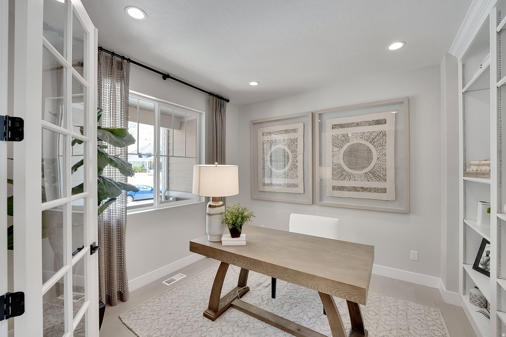 Interior space featuring French doors with grid-patterned glass, recessed lighting, and a built-in shelving unit. This is not the actual home being built but a representation of the features available in this home. Colors and finishes may differ from thos