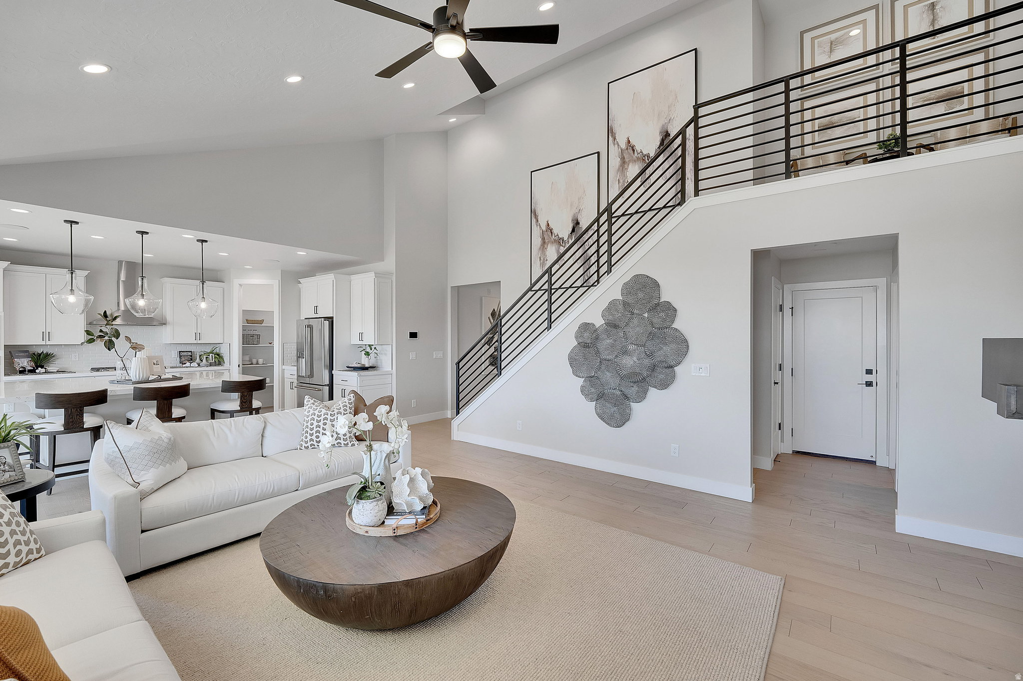 Open-concept living area featuring a vaulted ceiling and open rail. This is not the actual home being built but a representation of the features available in this home. Colors and finishes may differ from those shown. There will be a 1/2 pony wall instead
