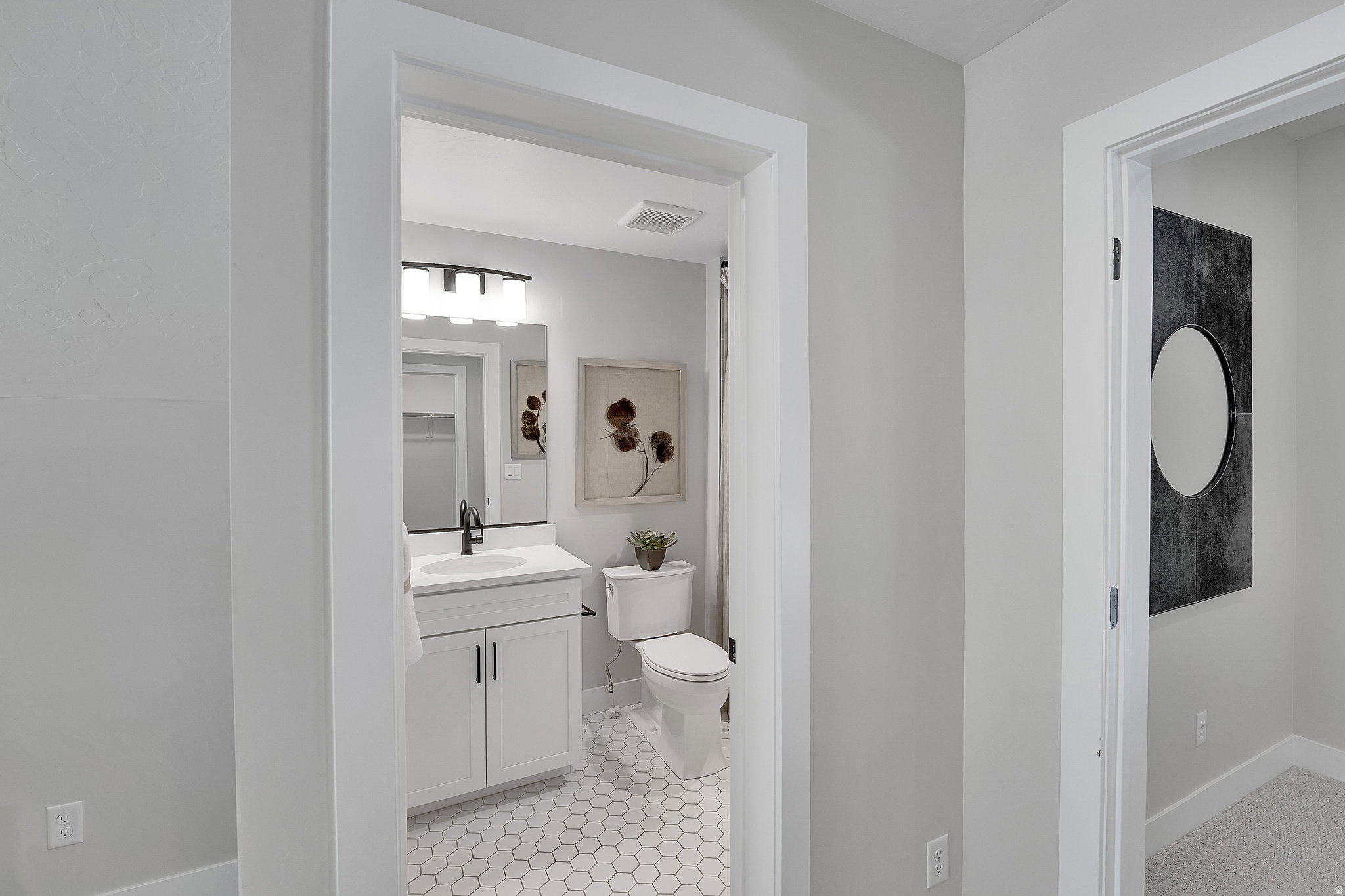 Bathroom featuring a white vanity with cabinet storage, a white countertop, and a rectangular undermount sink with a black faucet. This is not the actual home being built but a representation of the features available in this home. Colors and finishes may