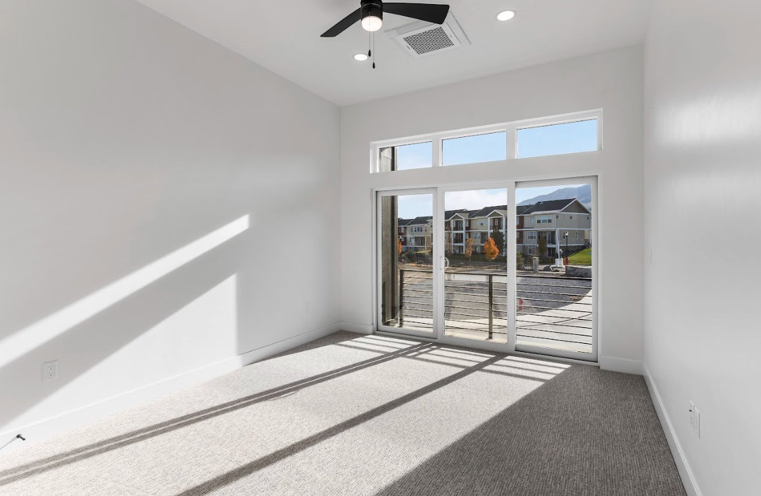 Spacious room with light gray carpet flooring and white walls