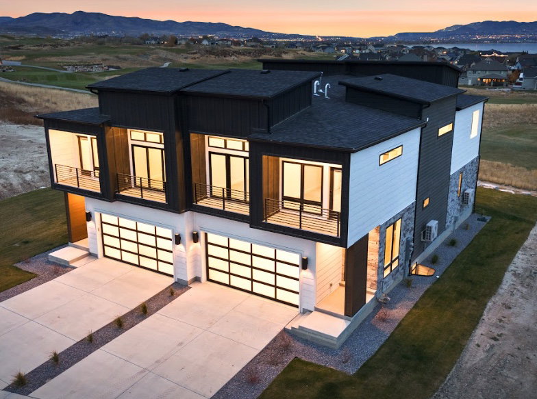Modern exterior featuring mixed materials including dark siding, light paneling, and stone accents