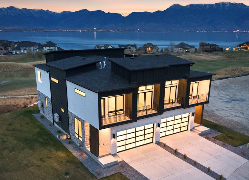 Modern architectural design featuring prominent balcony spaces and expansive glass-paneled garage doors