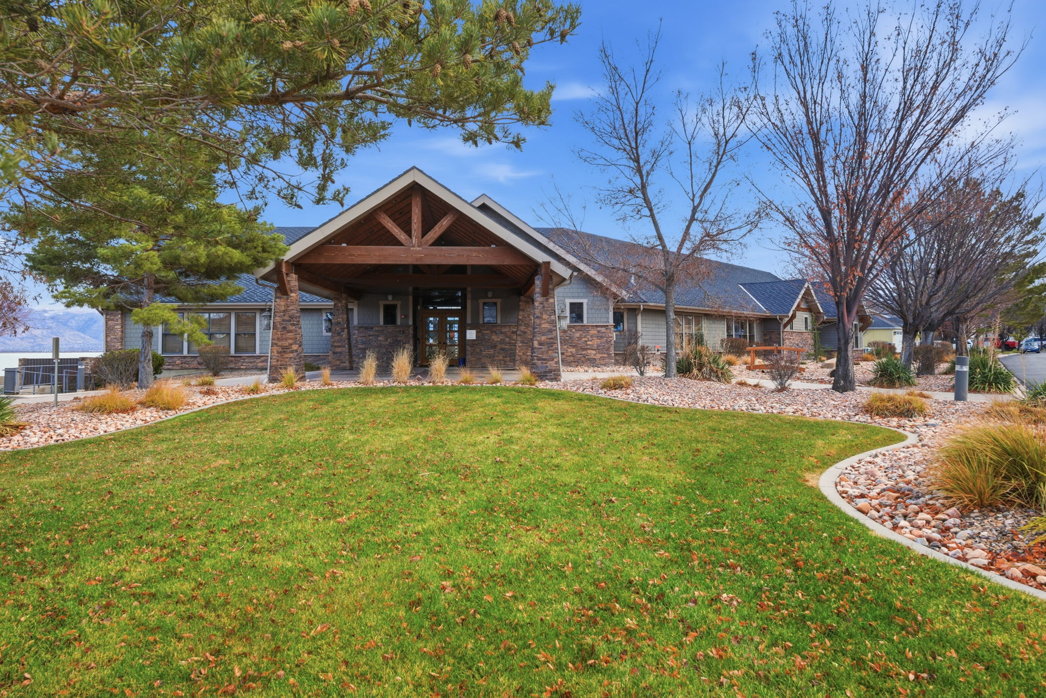 Stone and siding exterior with a prominent covered entry featuring exposed wood beams