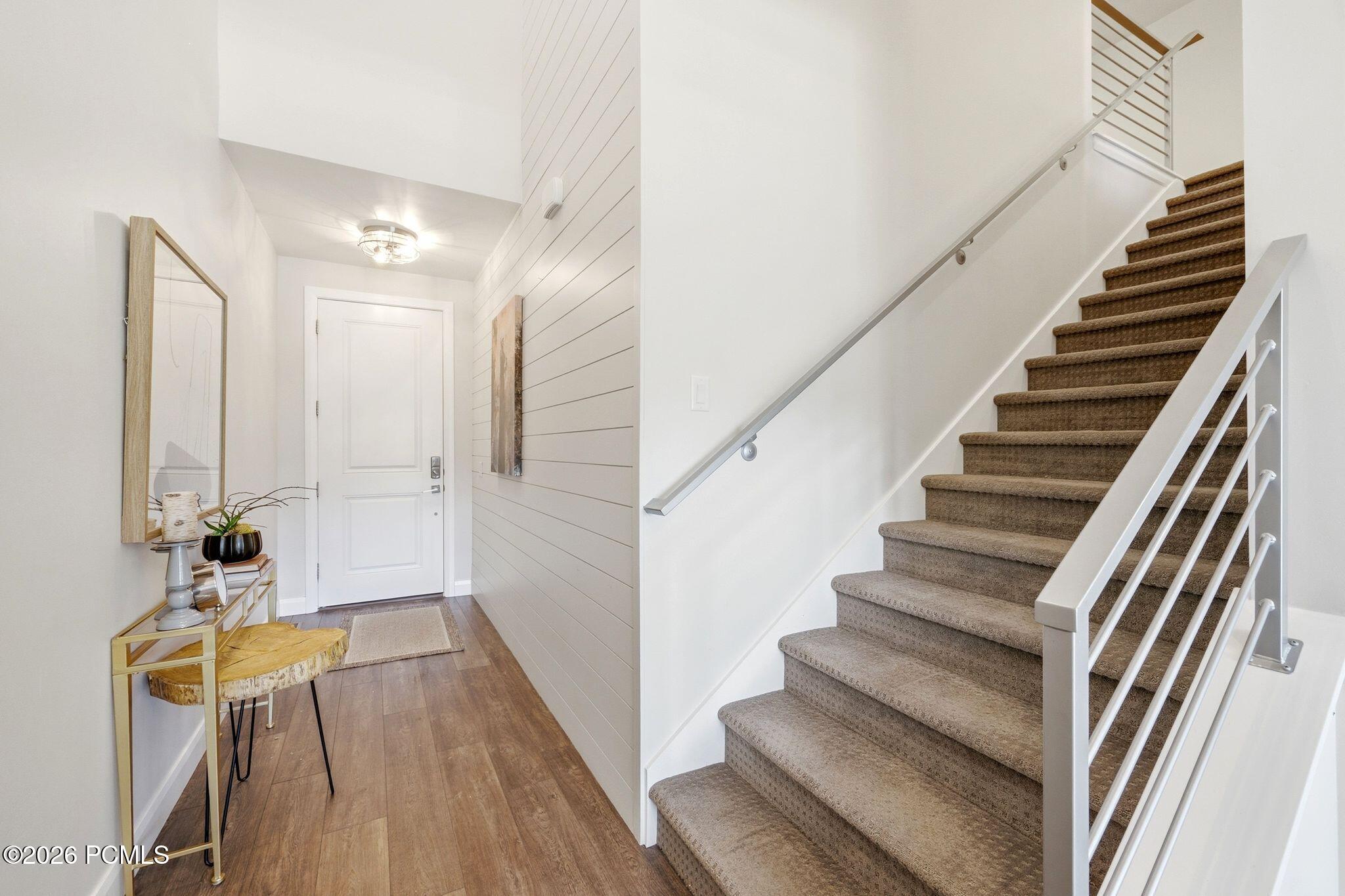 Foyer featuring wood-finish flooring and shiplap accent wall