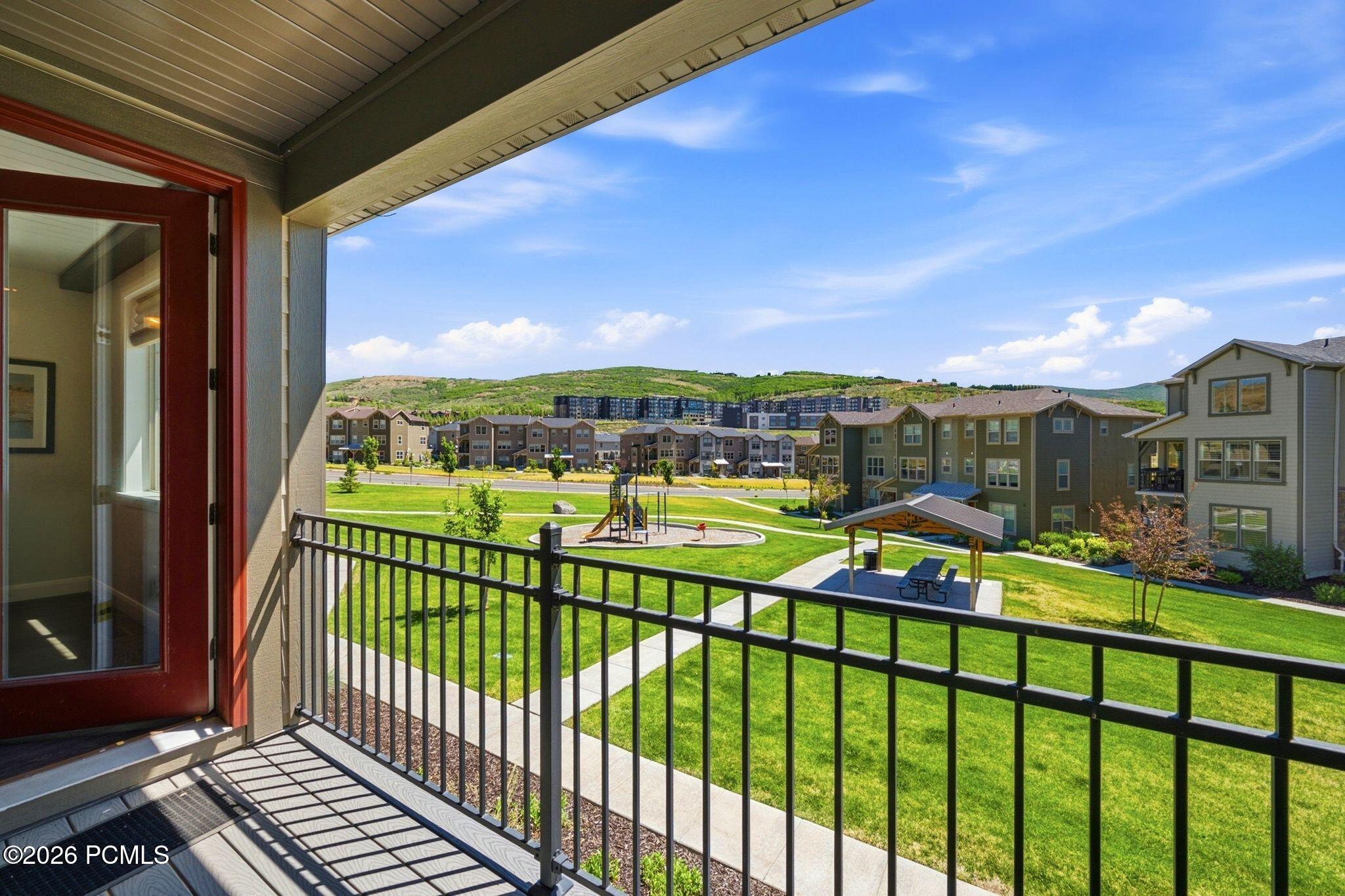 Balcony featuring a red-framed glass door, composite decking, and black metal railing