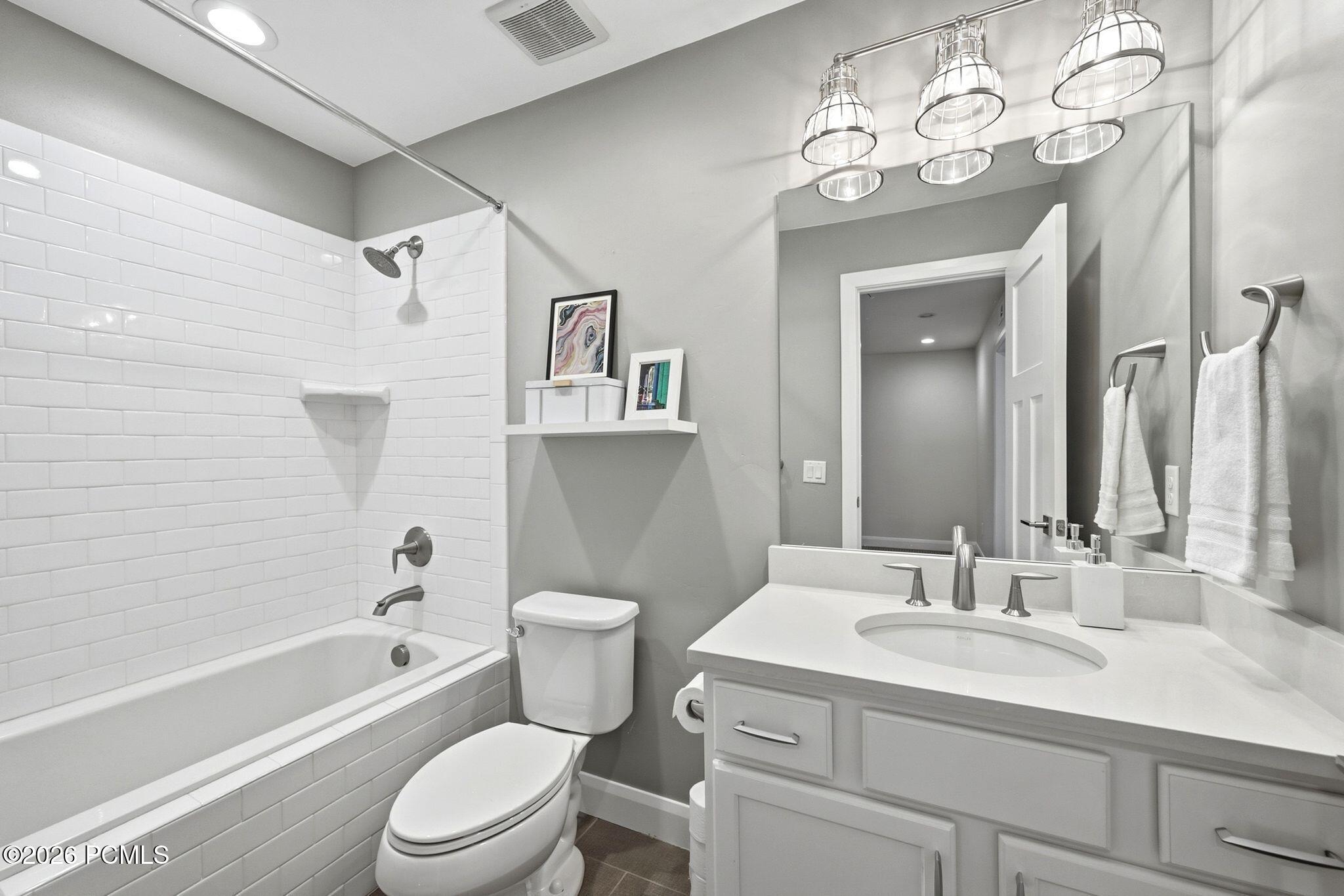 Contemporary bathroom featuring a white vanity with a rectangular undermount sink, brushed nickel faucet, and a large mirror