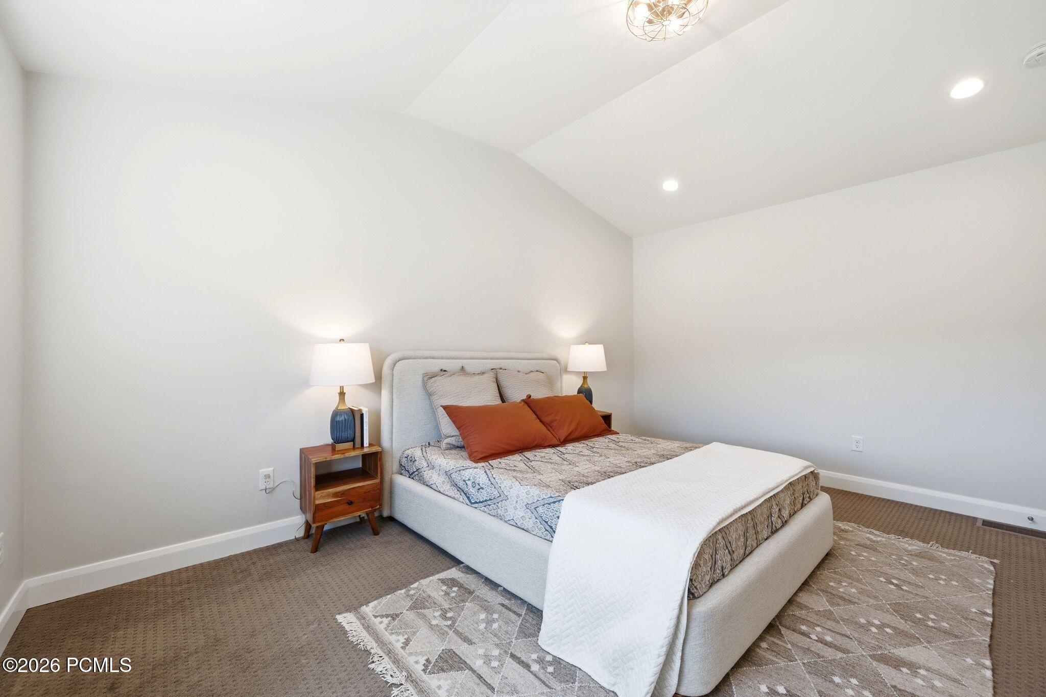Vaulted ceiling featuring a decorative flush mount light fixture and recessed lighting