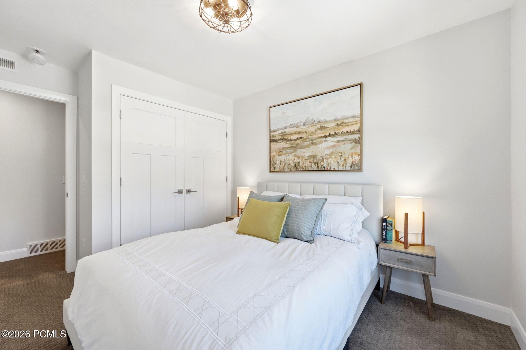 Bedroom featuring light-toned walls, white trim, and neutral-toned carpeting