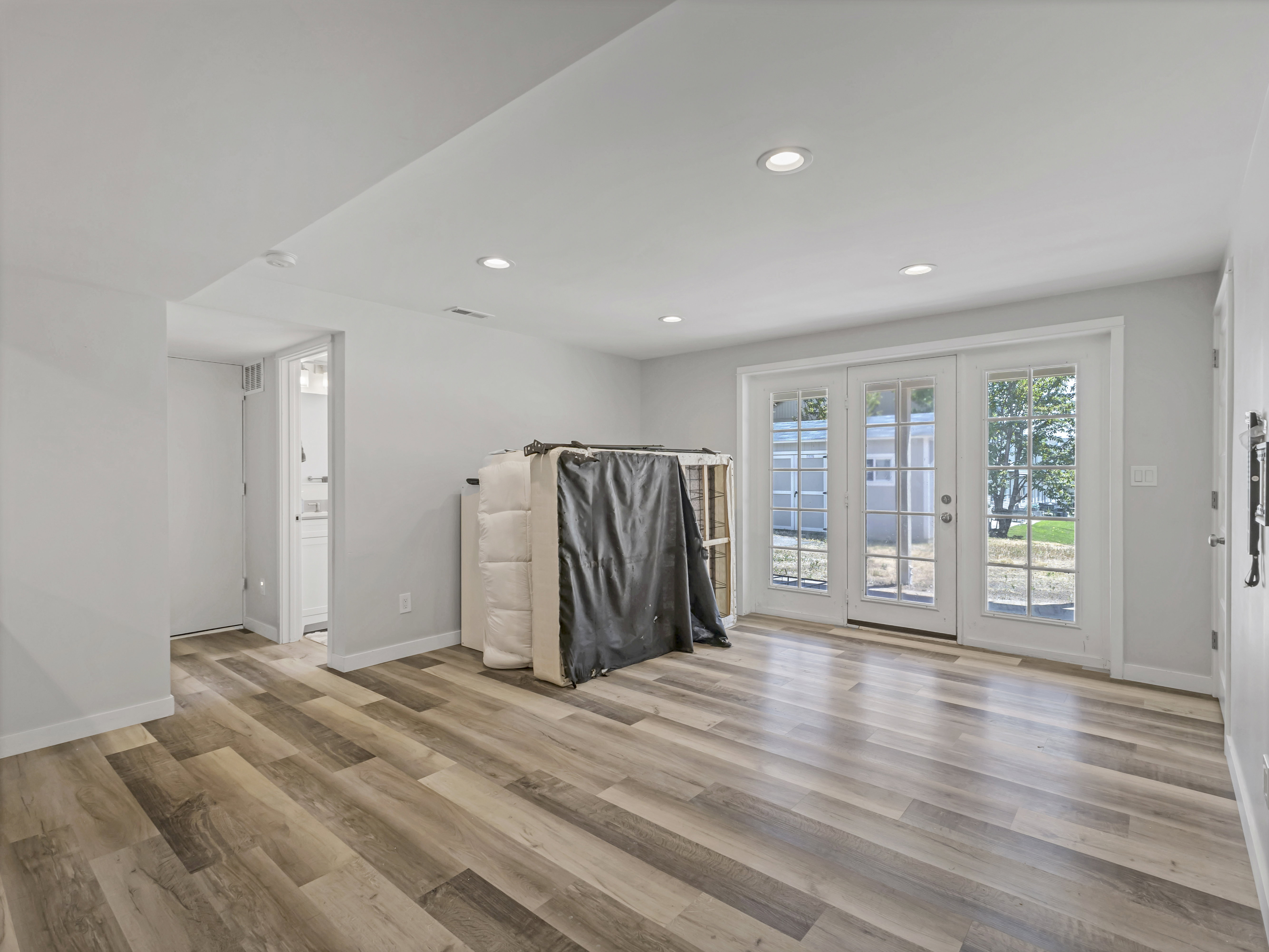Spacious room featuring wood-finish flooring, recessed lighting, and white walls