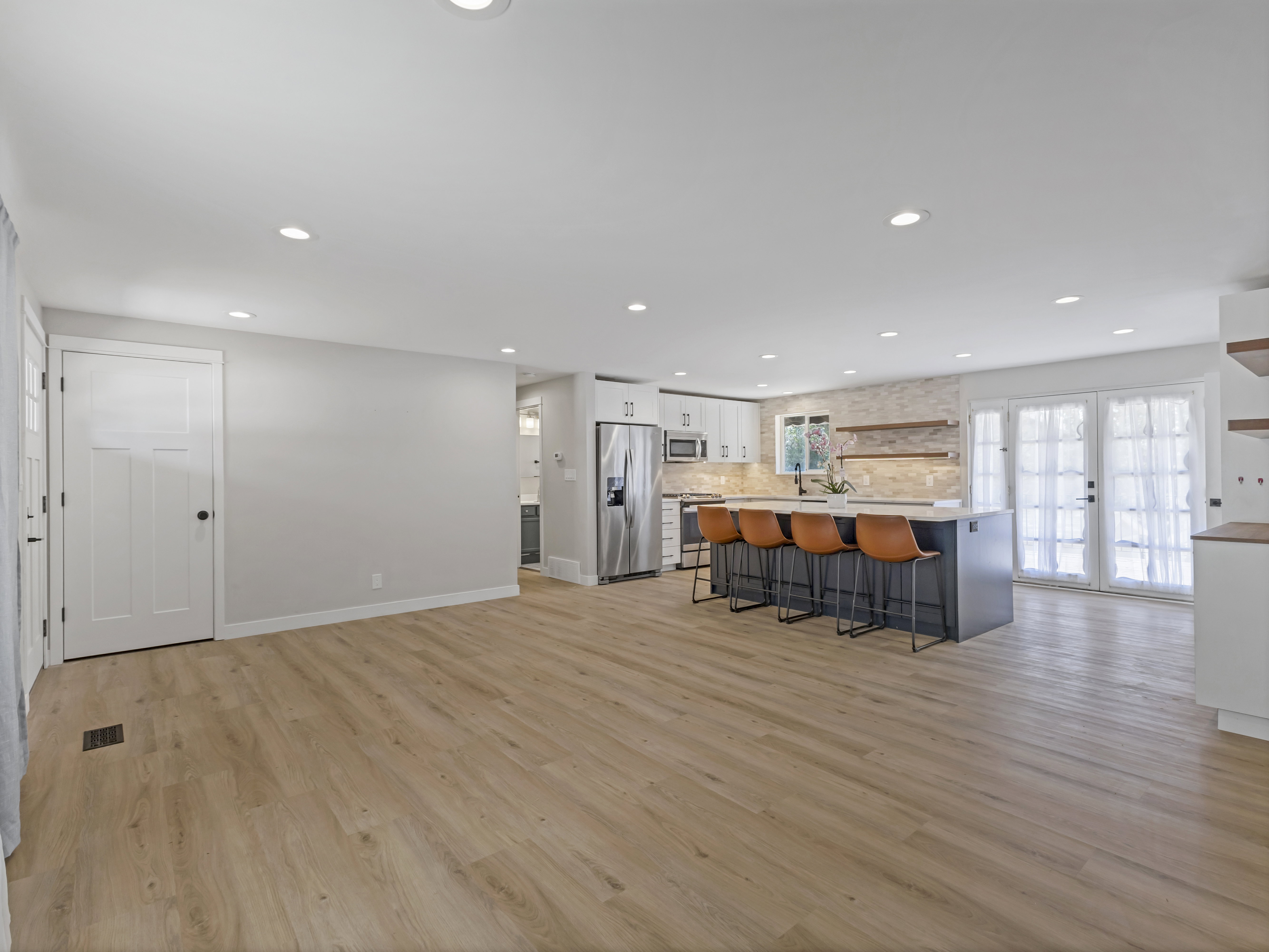 Bright kitchen and living area featuring wood-finish flooring