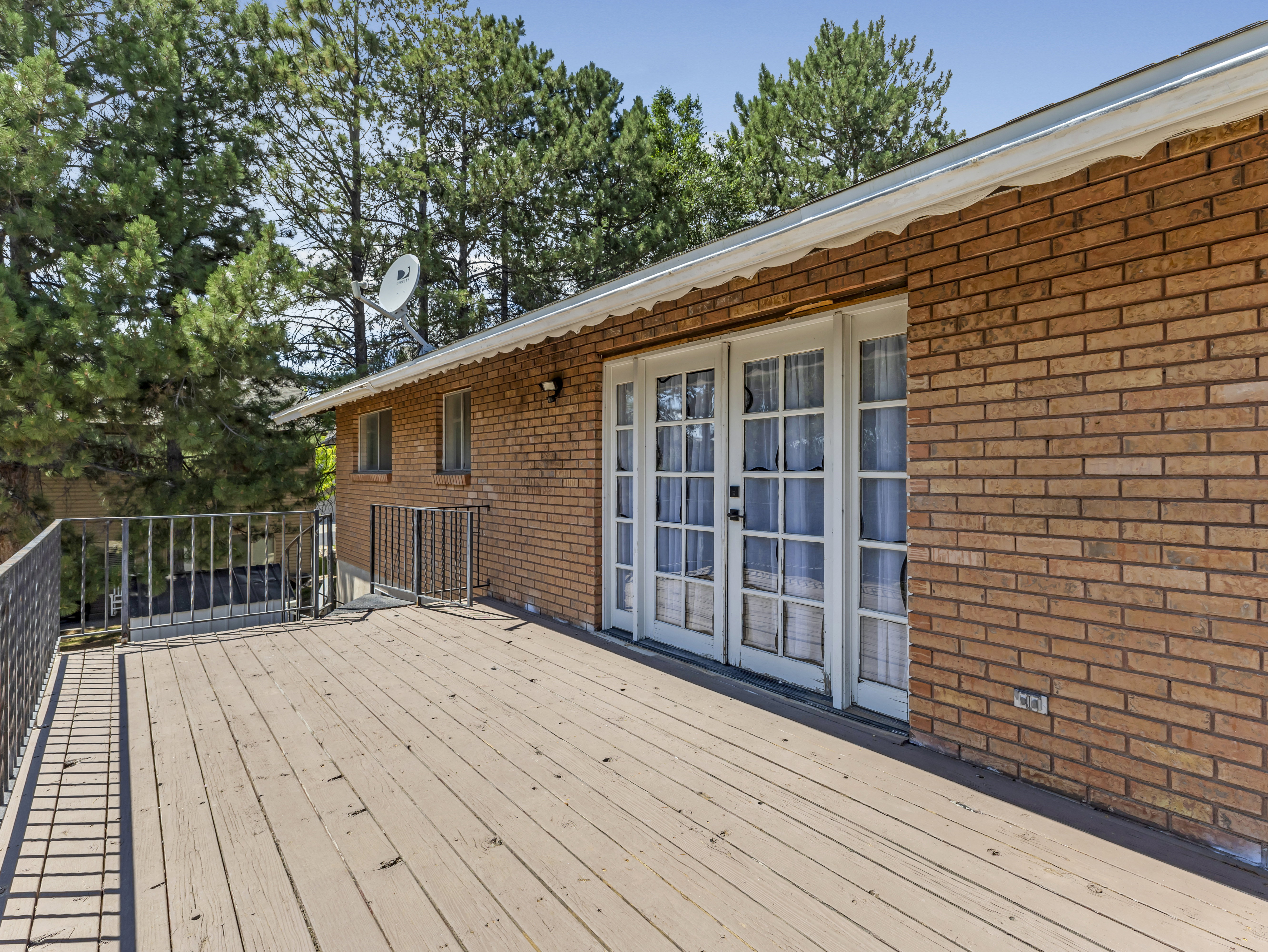 Spacious wood-finish deck with black metal railing
