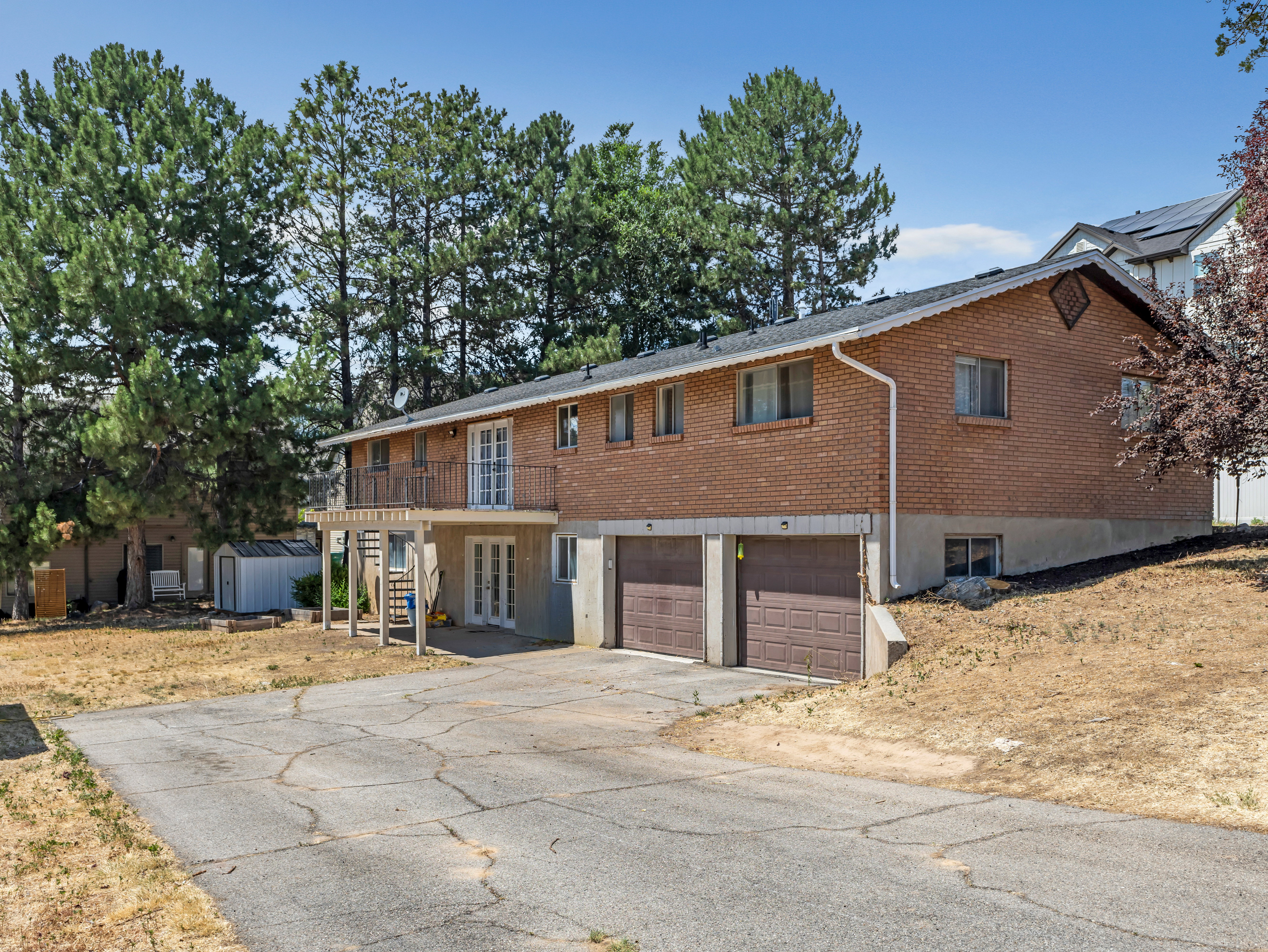 Brick exterior with a second-story balcony featuring metal railings and French doors