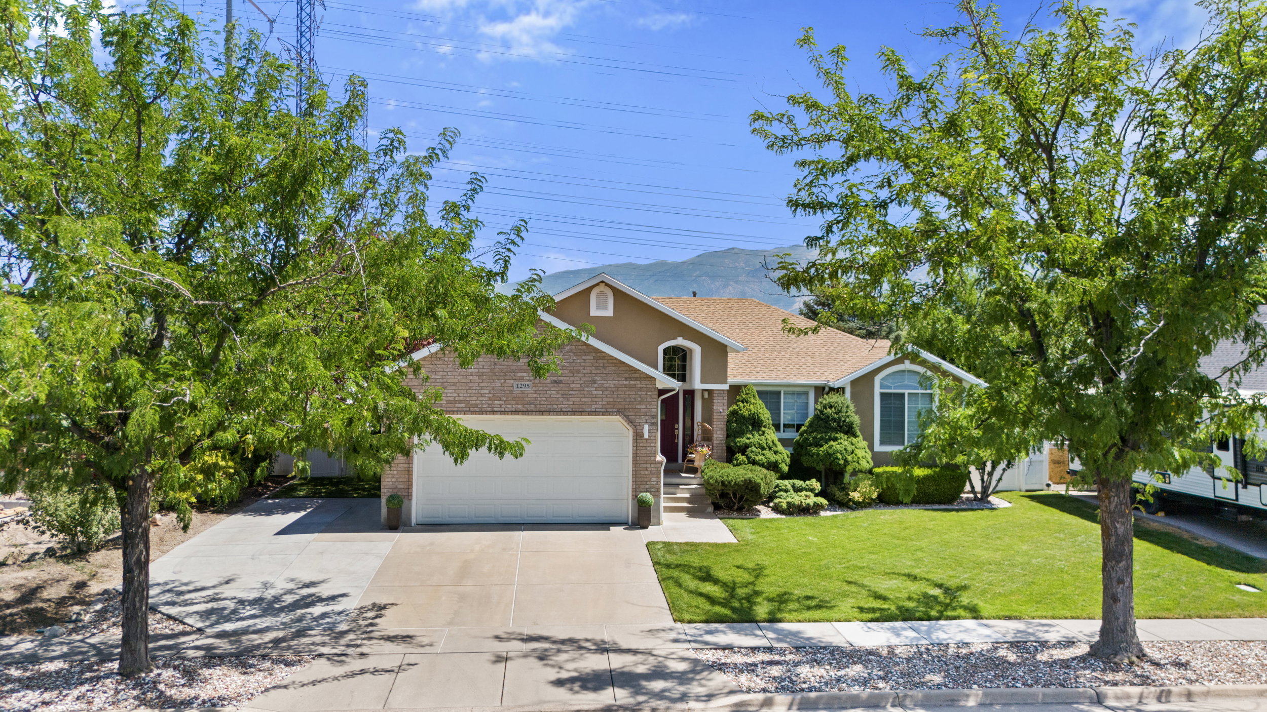 Brick and stucco exterior with an attached garage and a wide driveway