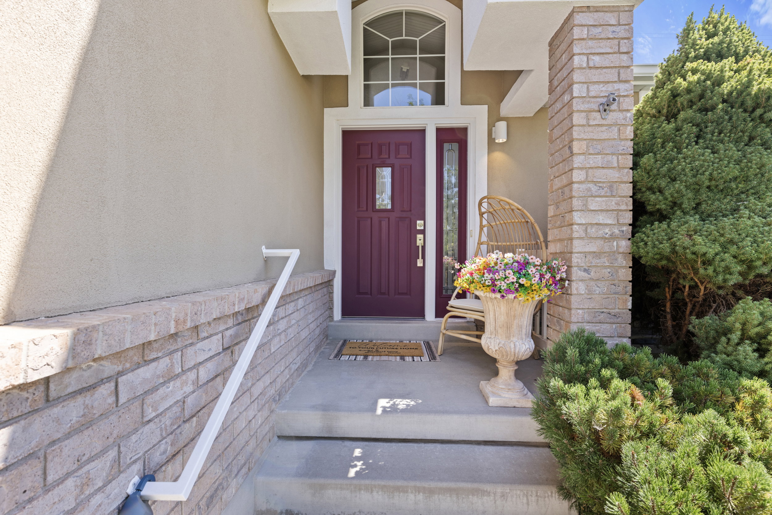 Entryway featuring a rich plum-colored door with decorative glass, an arched transom window, and a sidelight