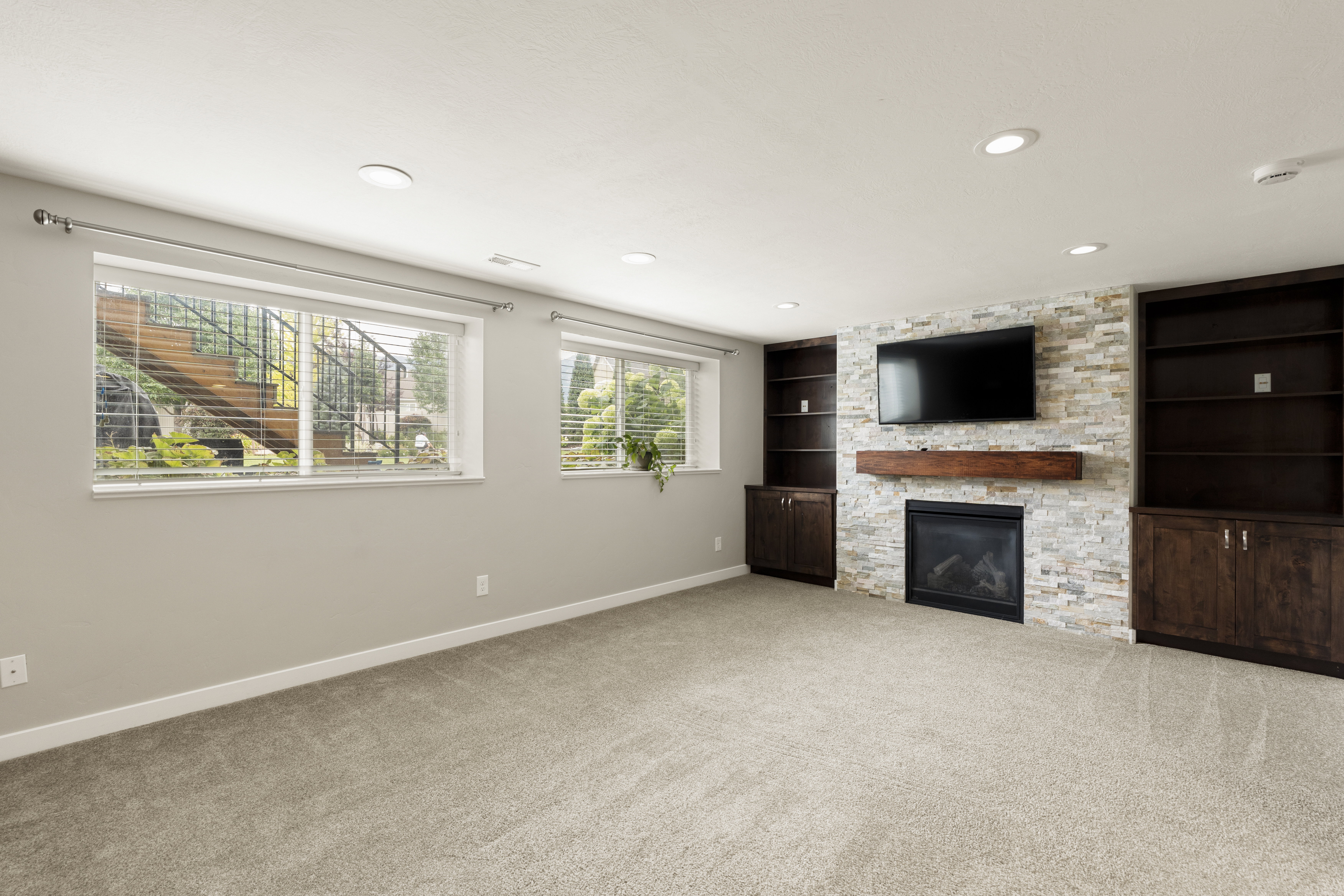 Spacious living area featuring a stone accent wall with an integrated fireplace and wood mantel