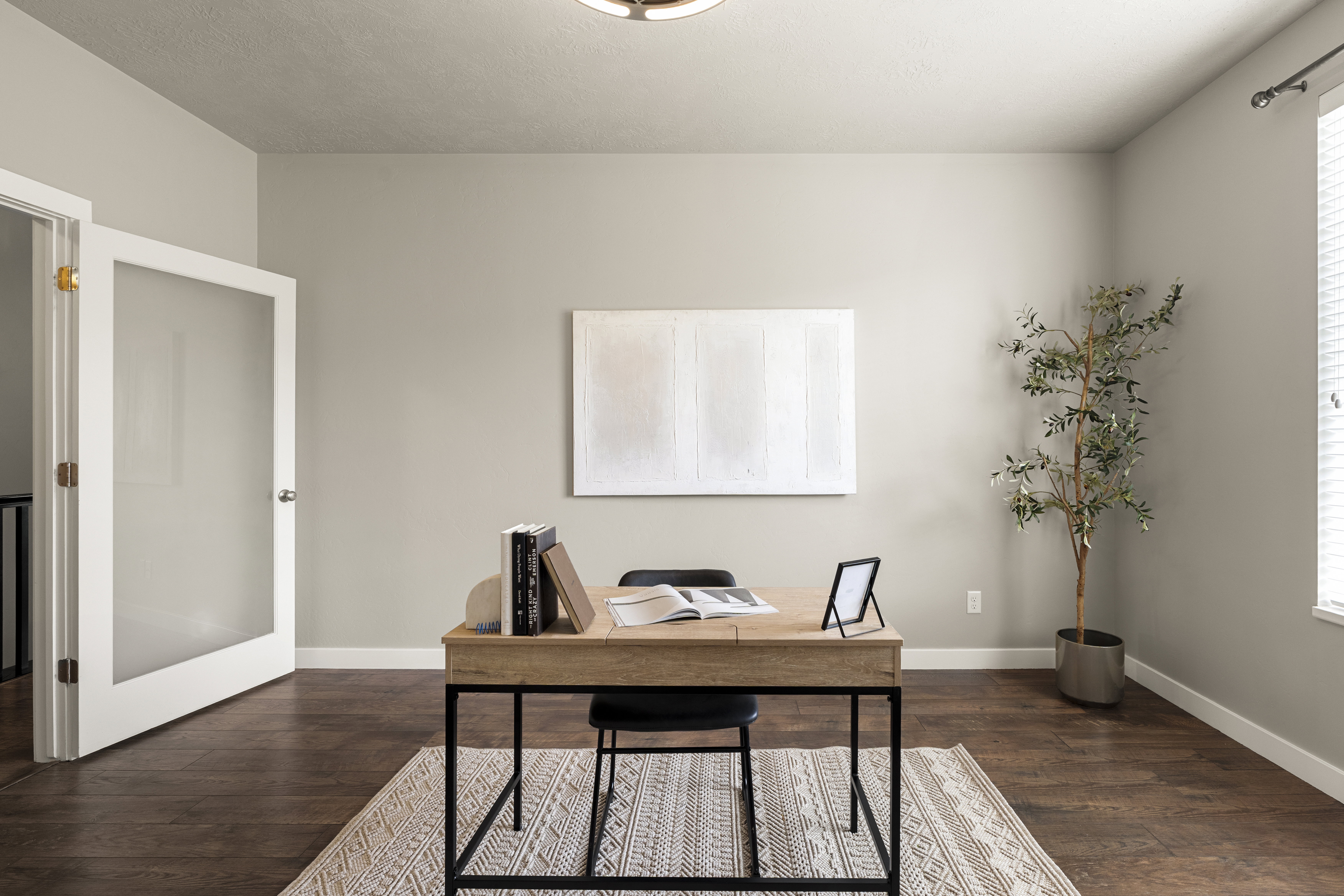 Light-filled room featuring wood-finish flooring, neutral wall paint, and a window with blinds
