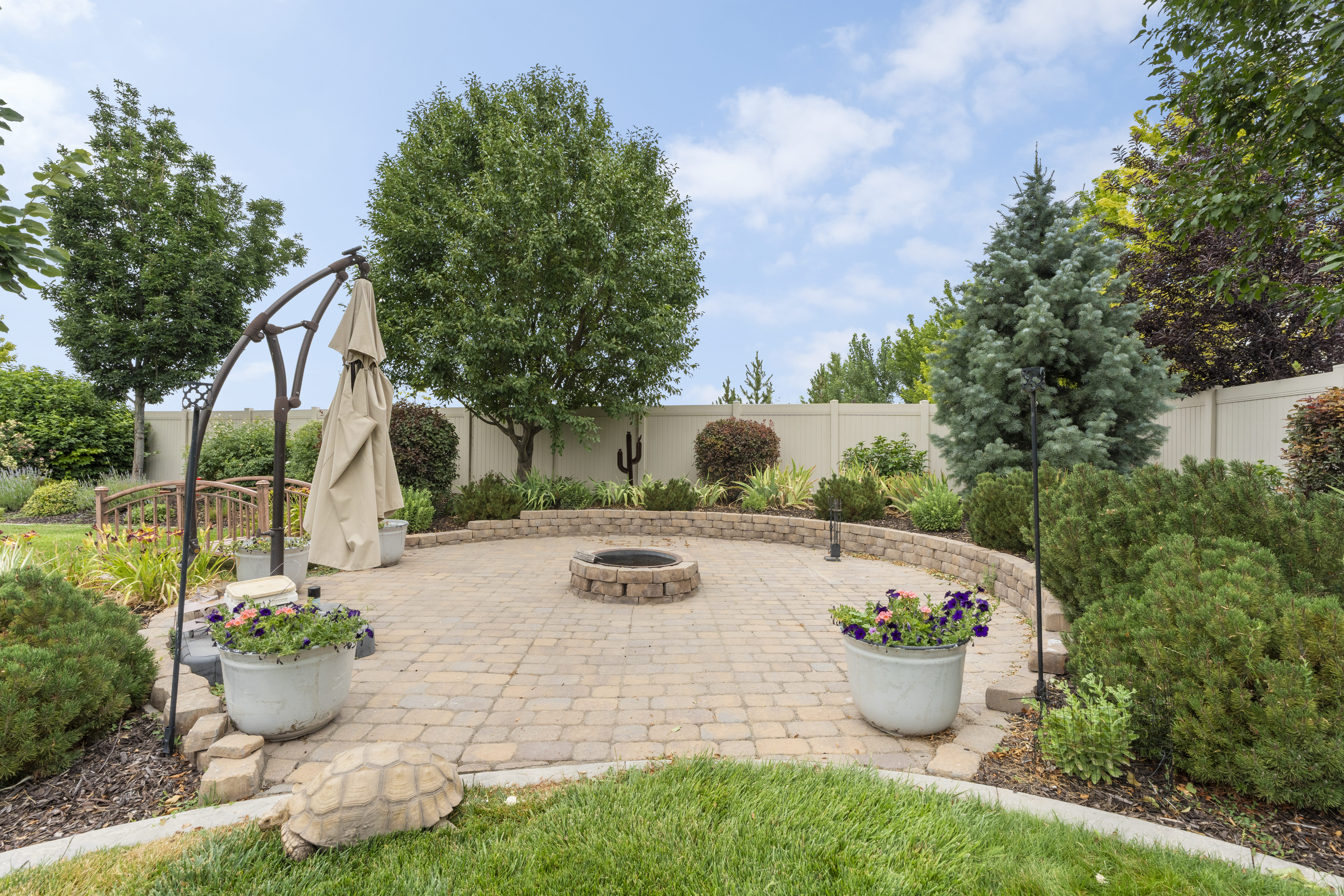 Paver patio with a built-in stone fire pit, surrounded by a stone retaining wall