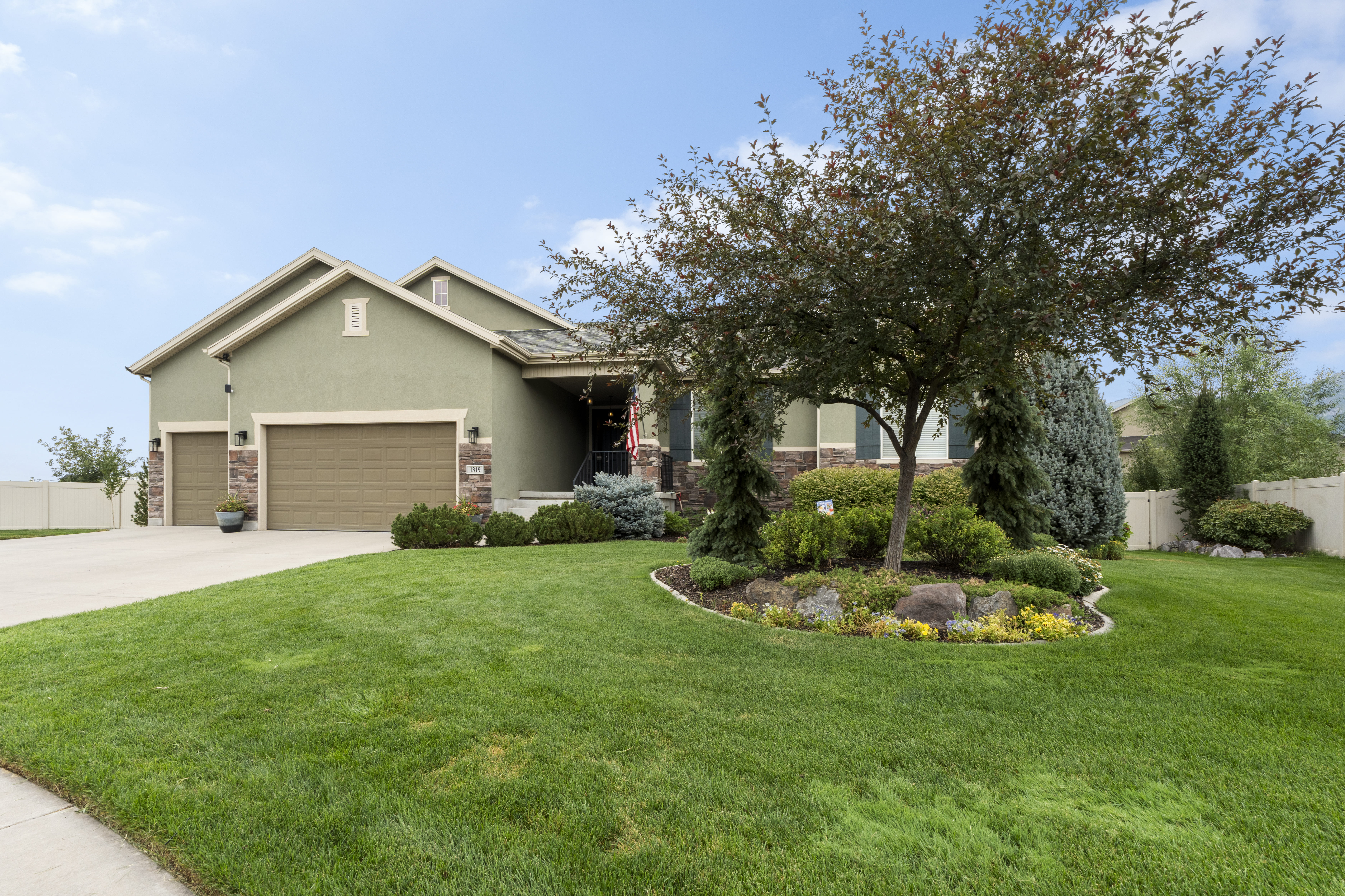 Stucco exterior with stone accents and twin garage doors