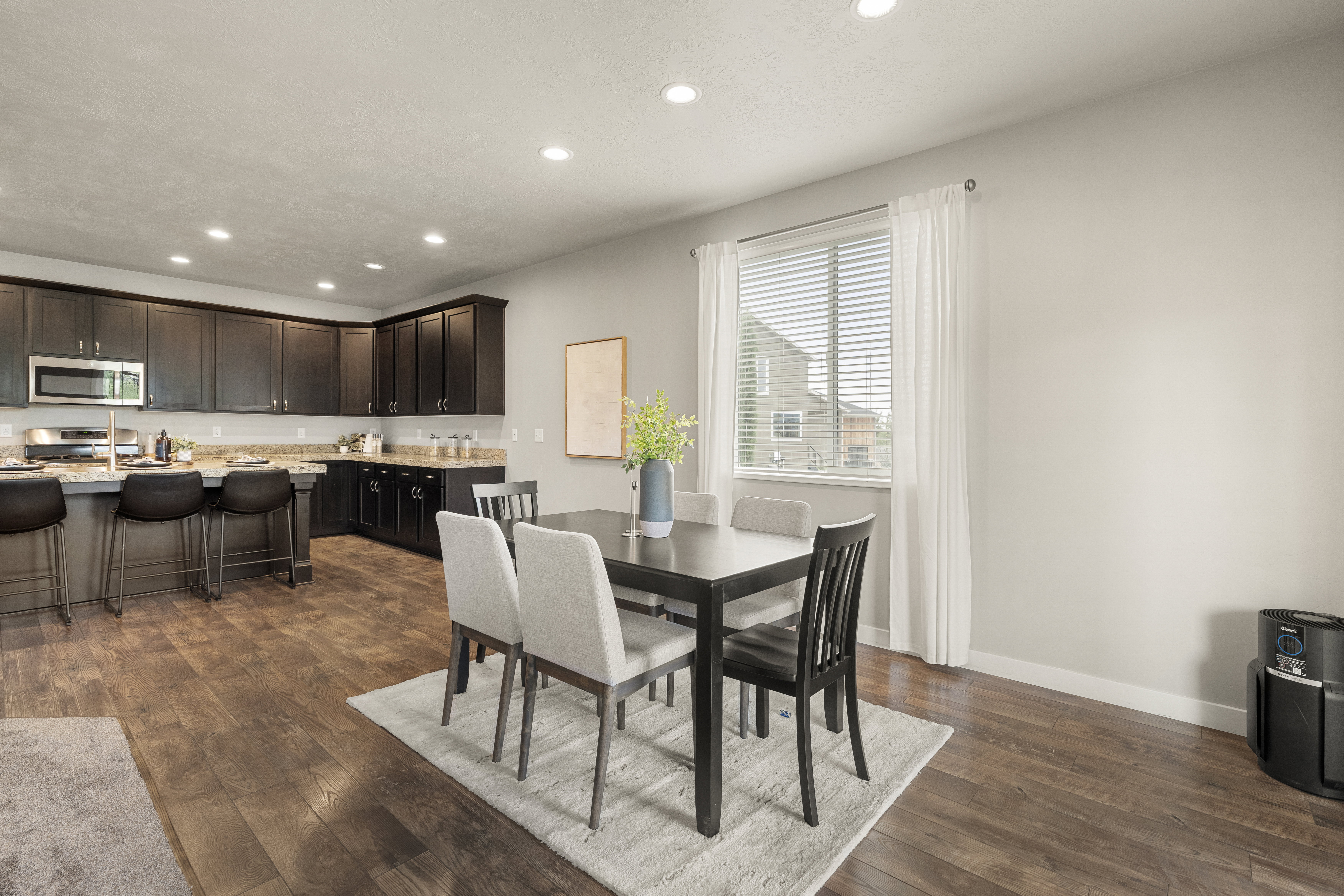 Open-concept living area featuring rich wood-finish flooring