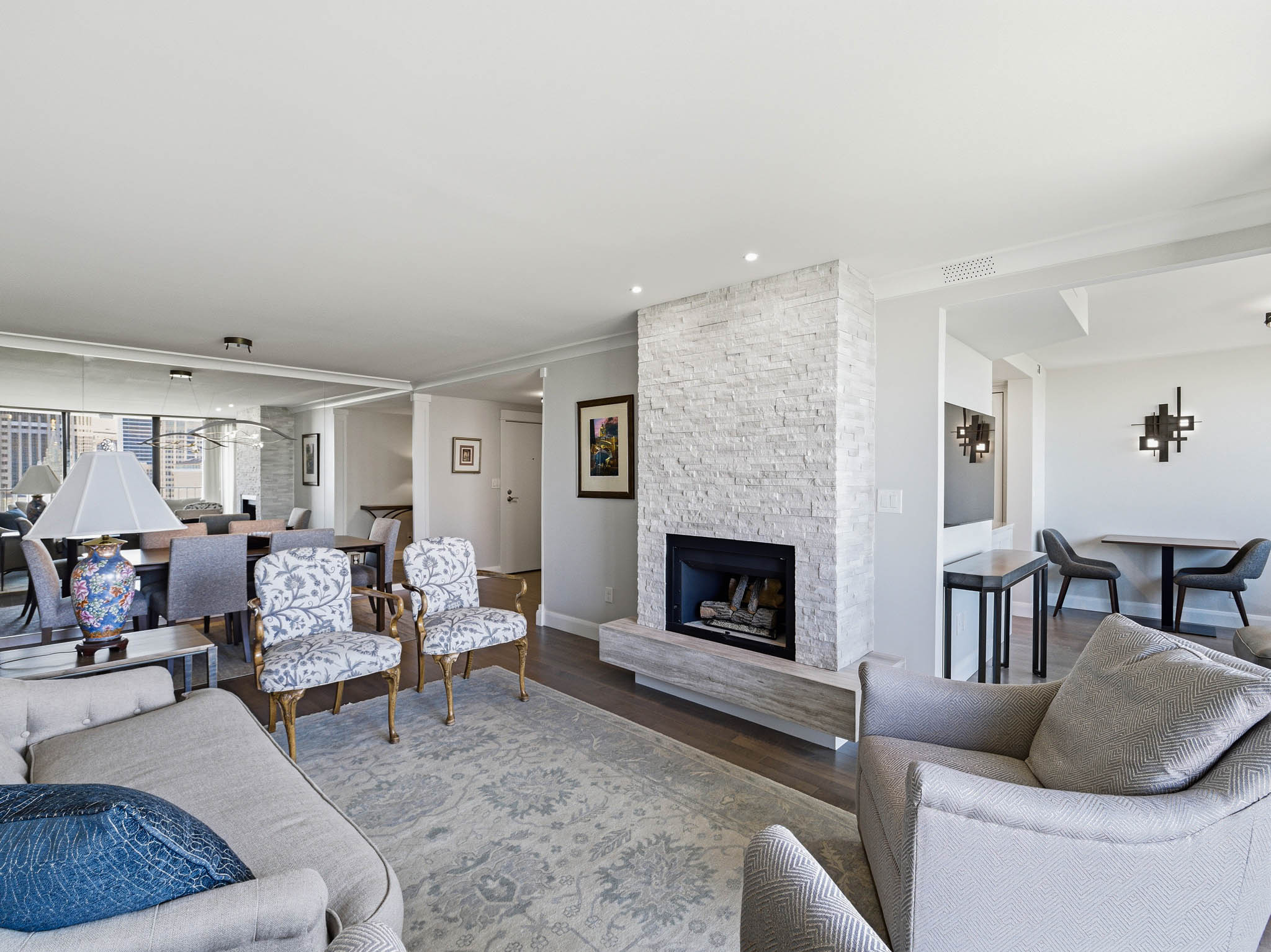 Living area featuring a floor-to-ceiling stone-clad fireplace with a hearth