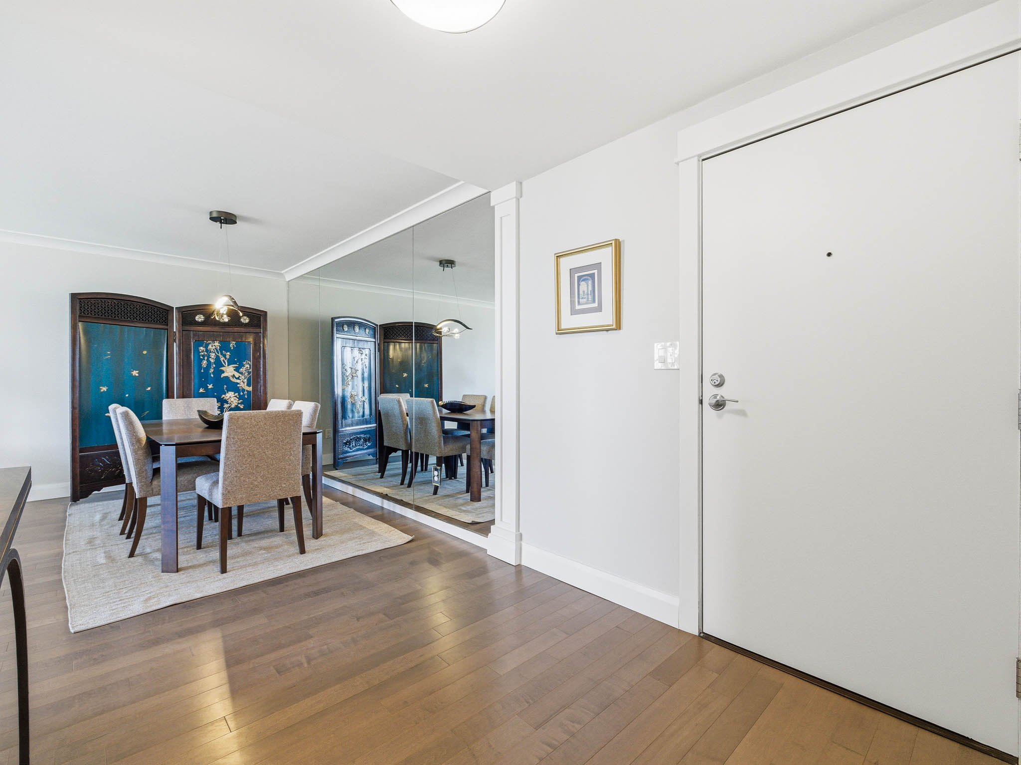 Light wood-finish flooring extending from the entryway into the dining area