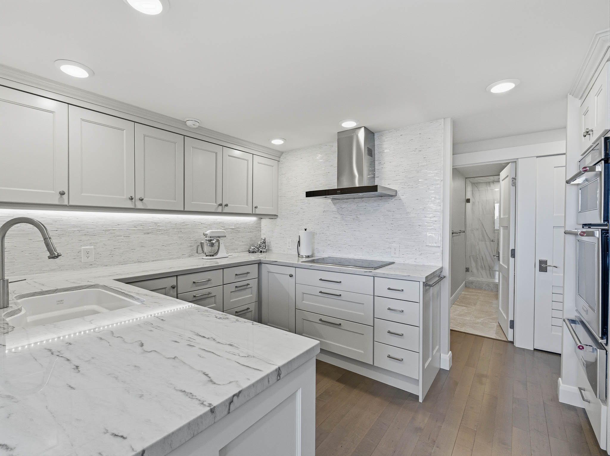Contemporary kitchen featuring light-toned cabinetry and countertops with integrated sink