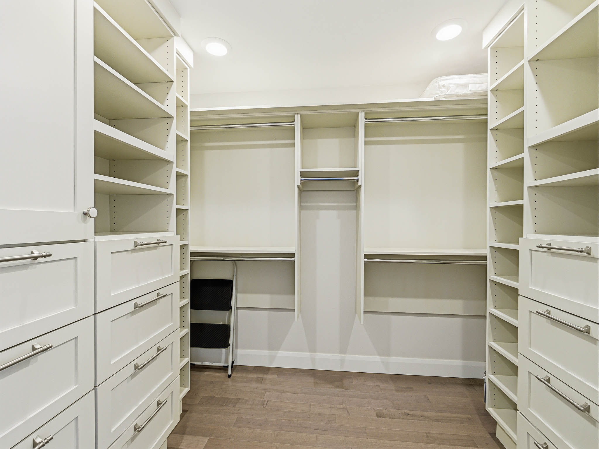 Custom closet system featuring extensive shelving and built-in drawers with brushed nickel hardware