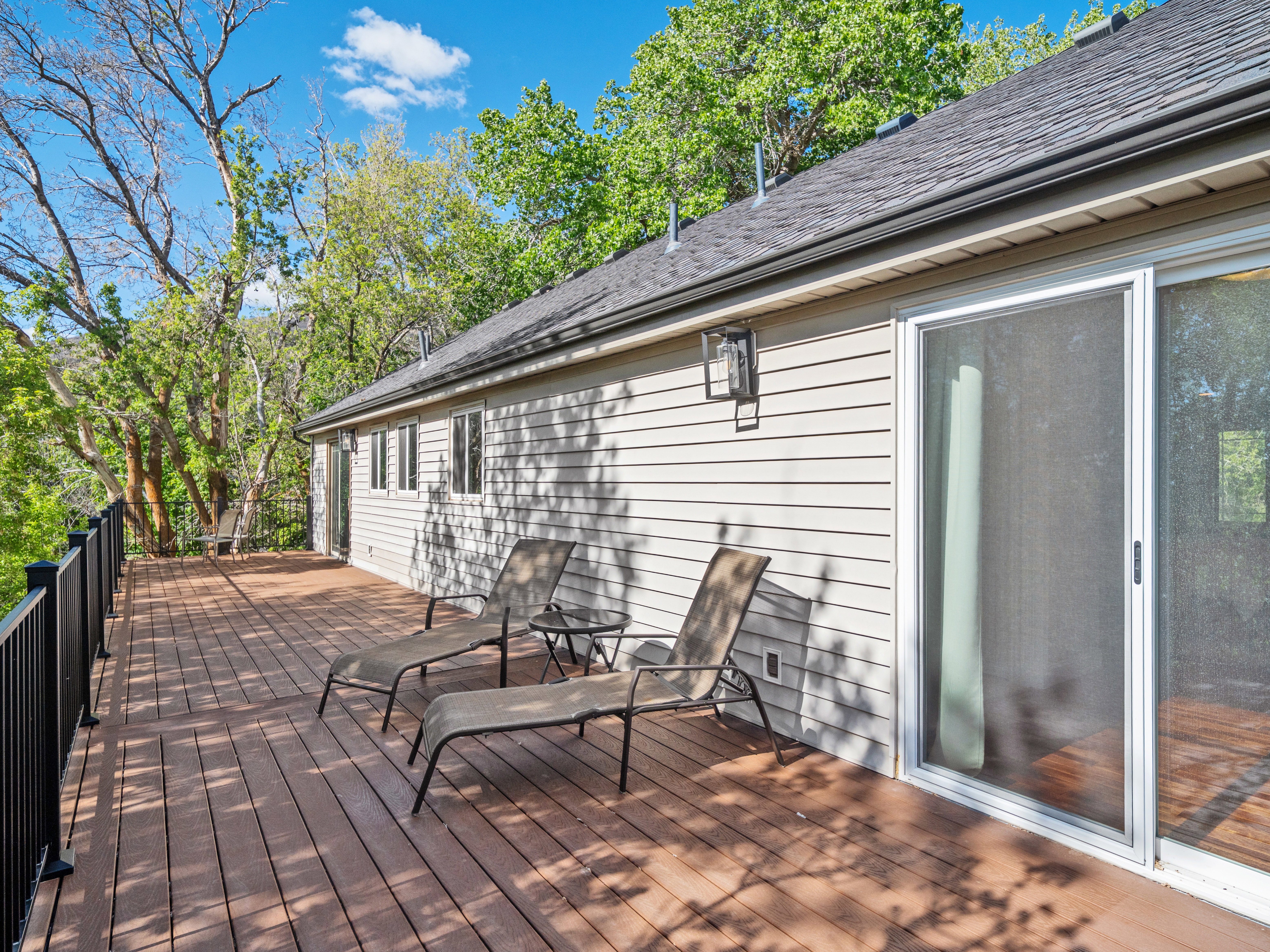 Spacious outdoor deck featuring composite decking and black metal railings