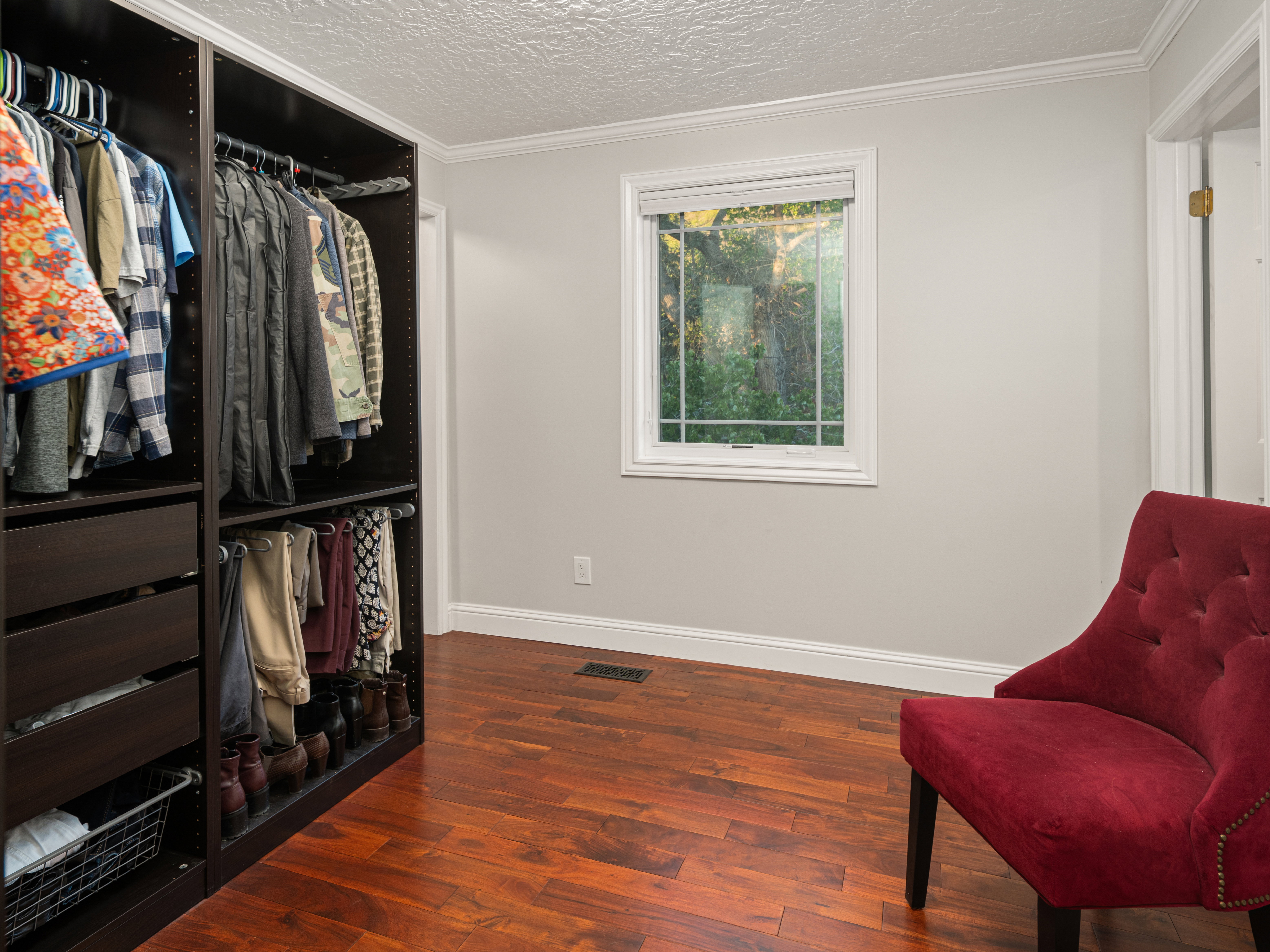Custom closet system with dark wood-finish components, offering both hanging and drawer storage