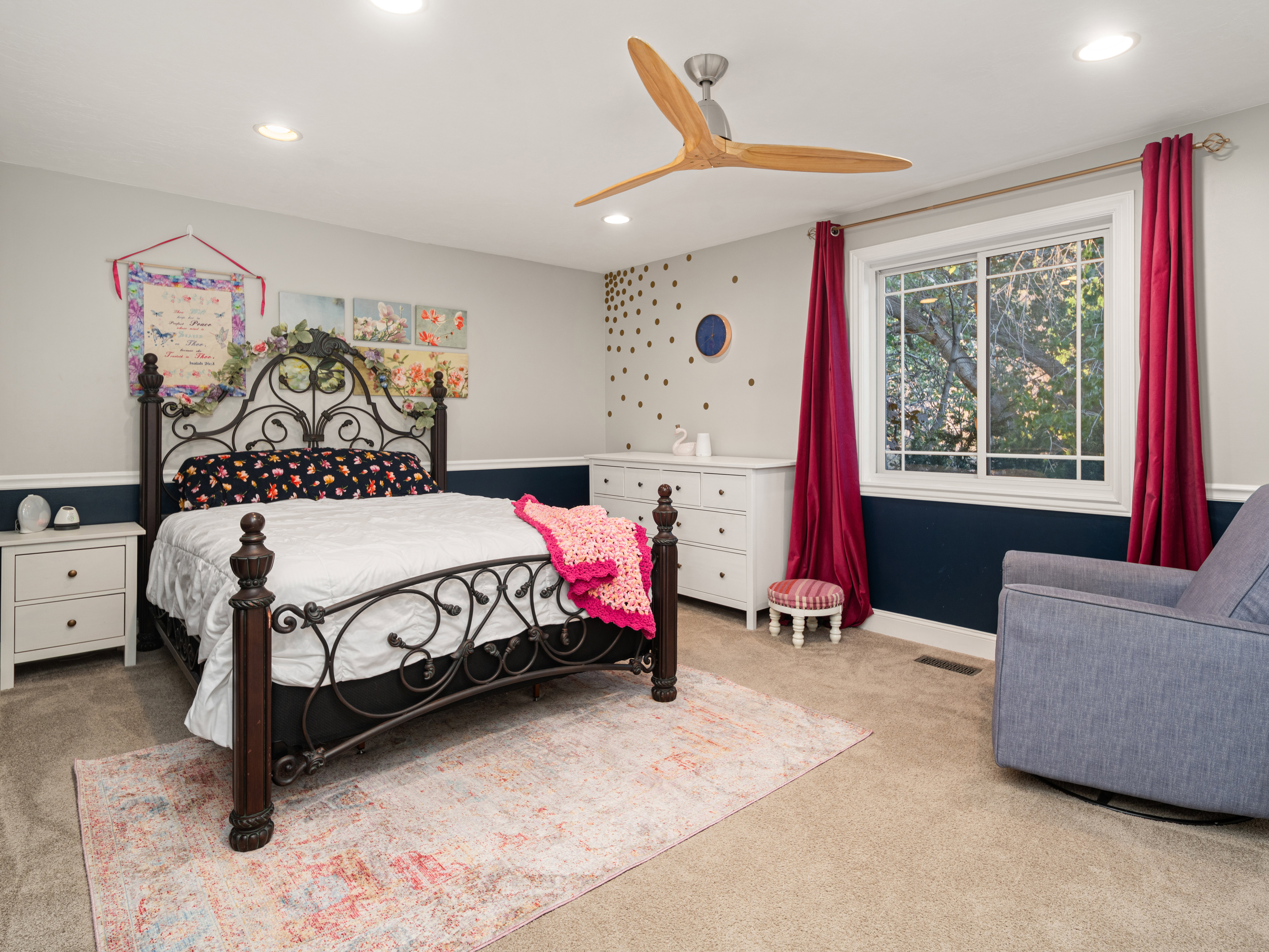 Recessed lighting and a modern ceiling fan illuminate this carpeted room featuring a window with natural light and a two-tone wall treatment