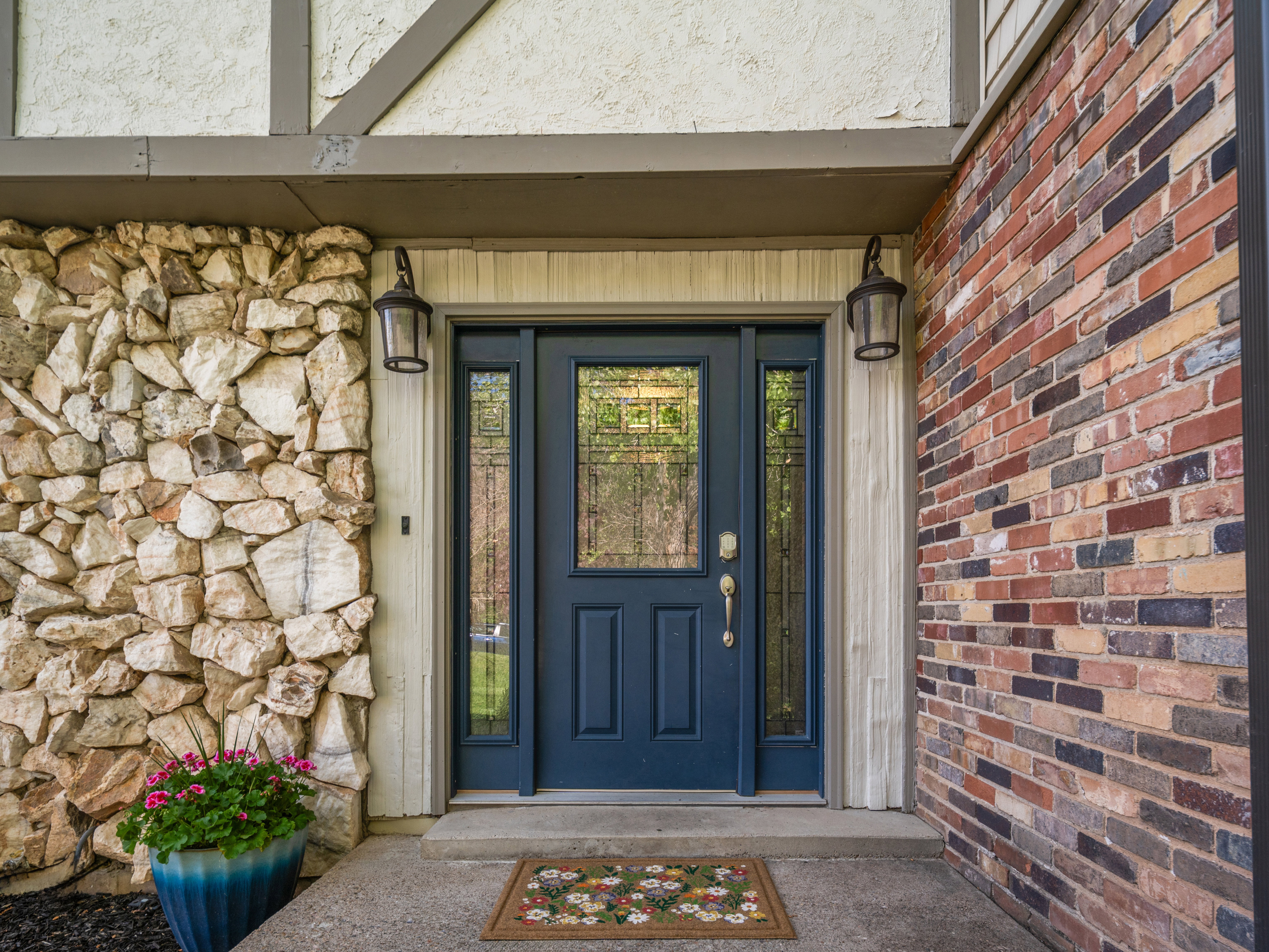 Entryway featuring a dark blue door with decorative glass inserts and sidelights