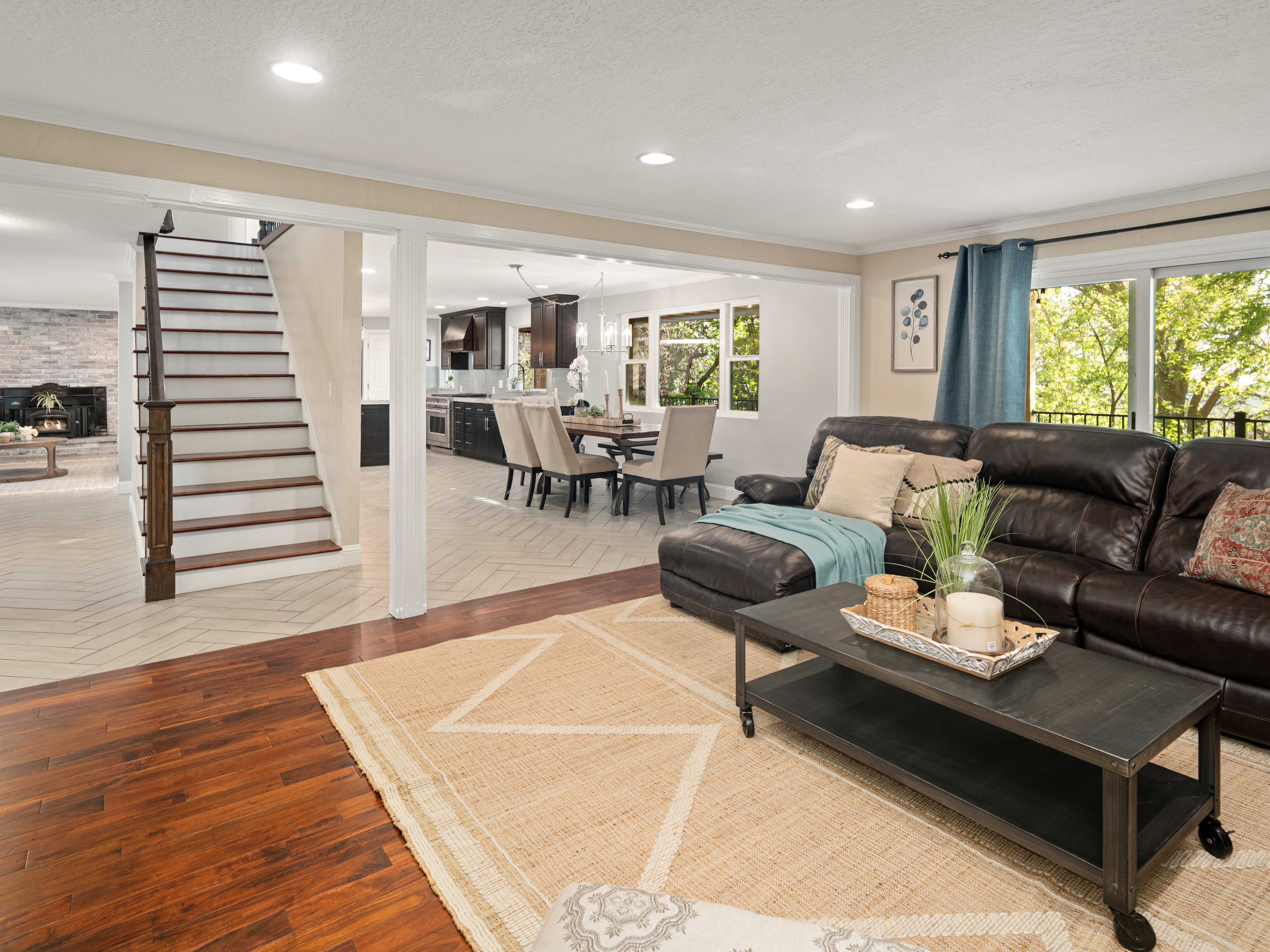 Open concept living space featuring rich wood-finish flooring, recessed lighting, and a staircase with wood-finish treads and balusters