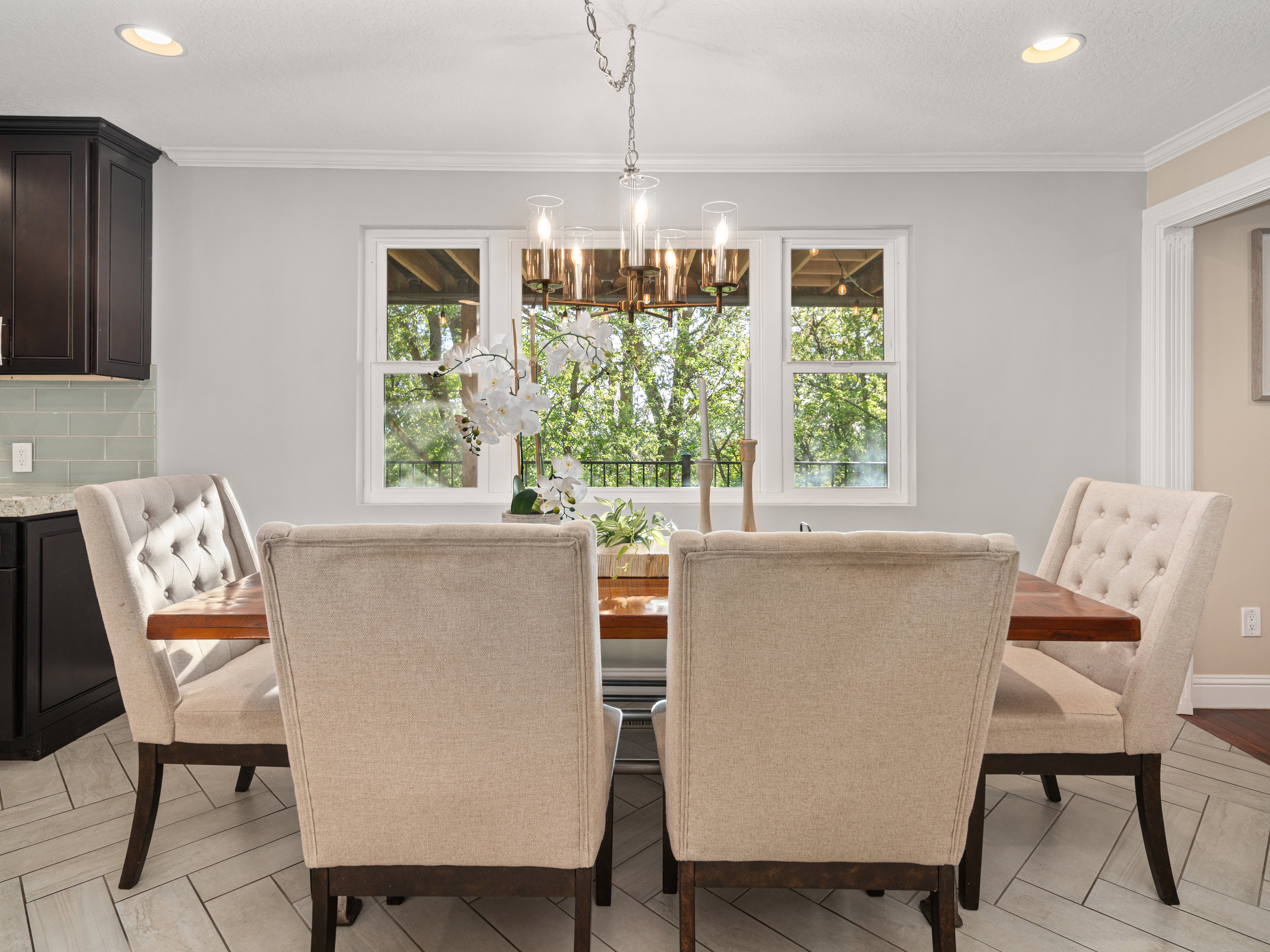 Dining area with a multi-pane window overlooking a wooded exterior