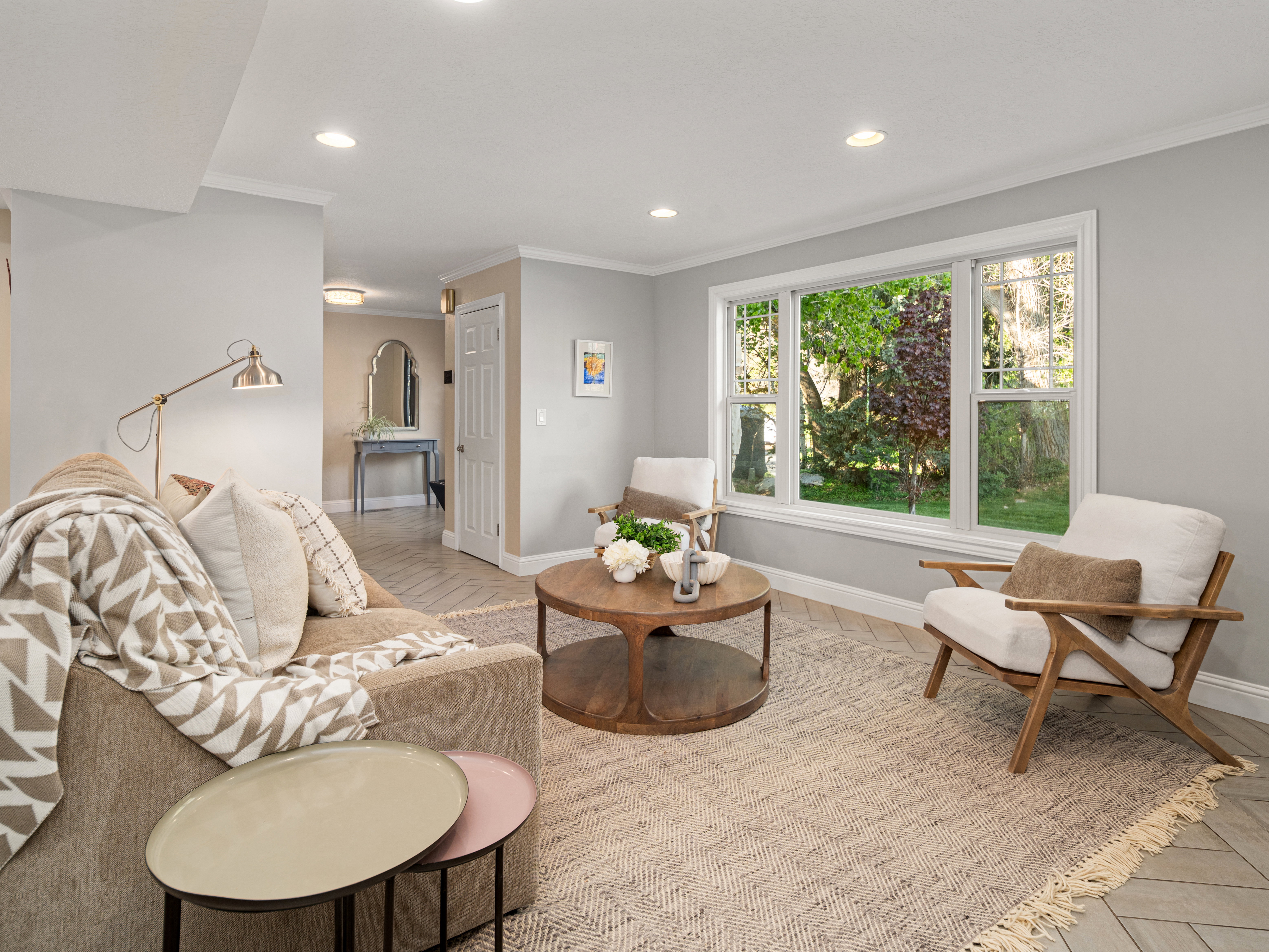 Sunlit living area featuring recessed lighting, crown molding, and herringbone-patterned wood-finish flooring