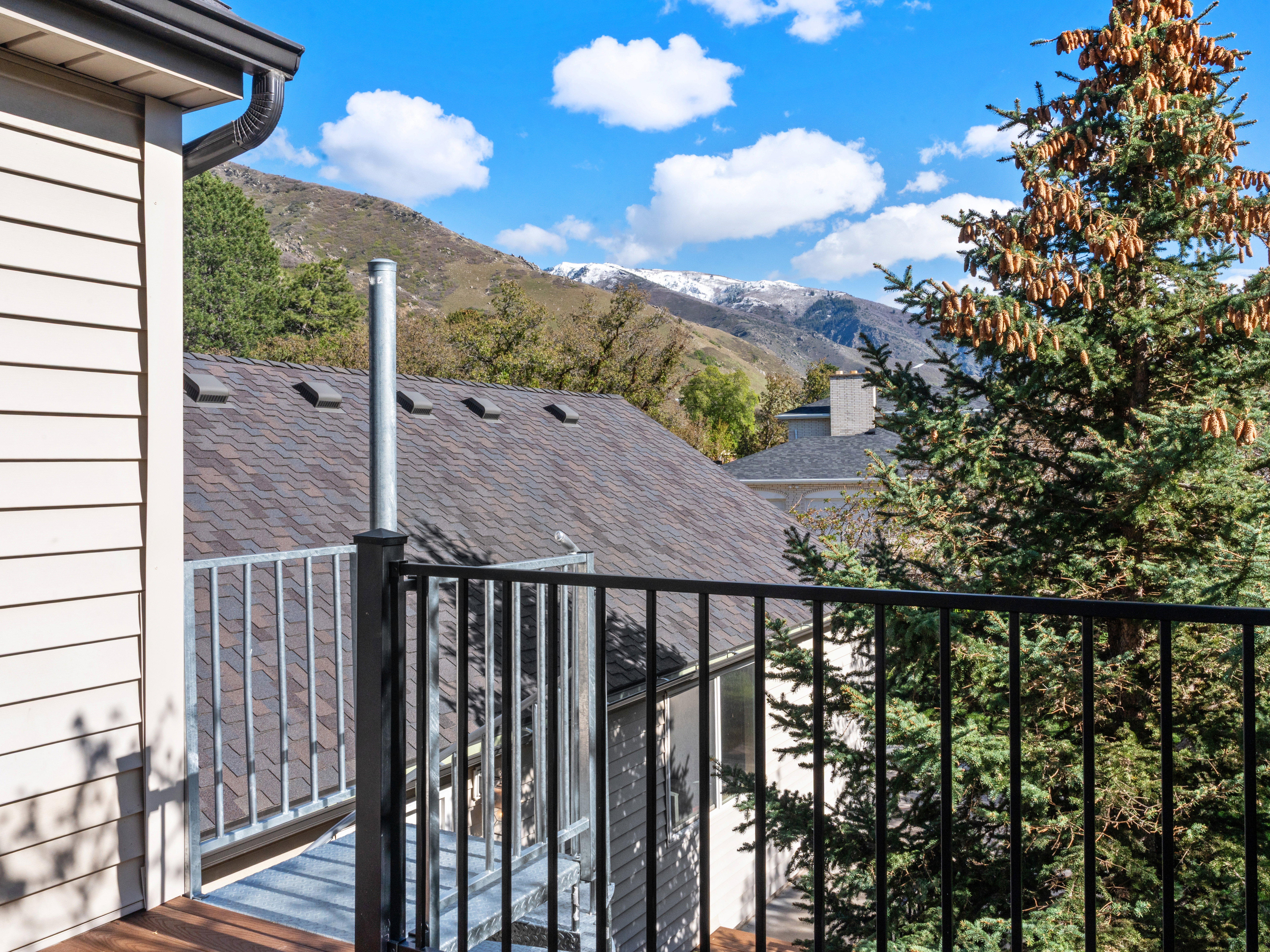 Outdoor balcony with metal railings and wood-finish flooring