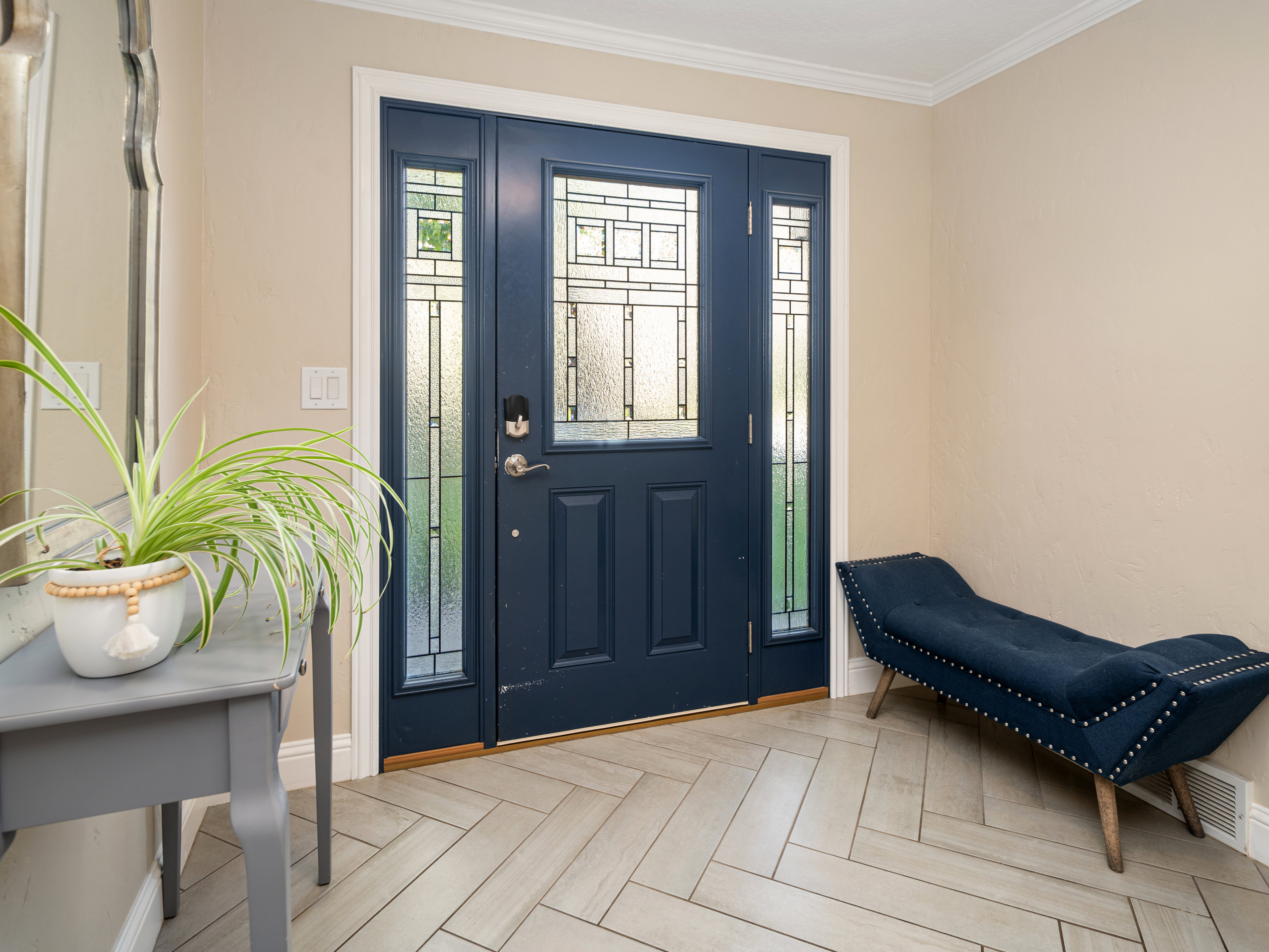 Entryway featuring a navy blue door with decorative glass inserts and two sidelights