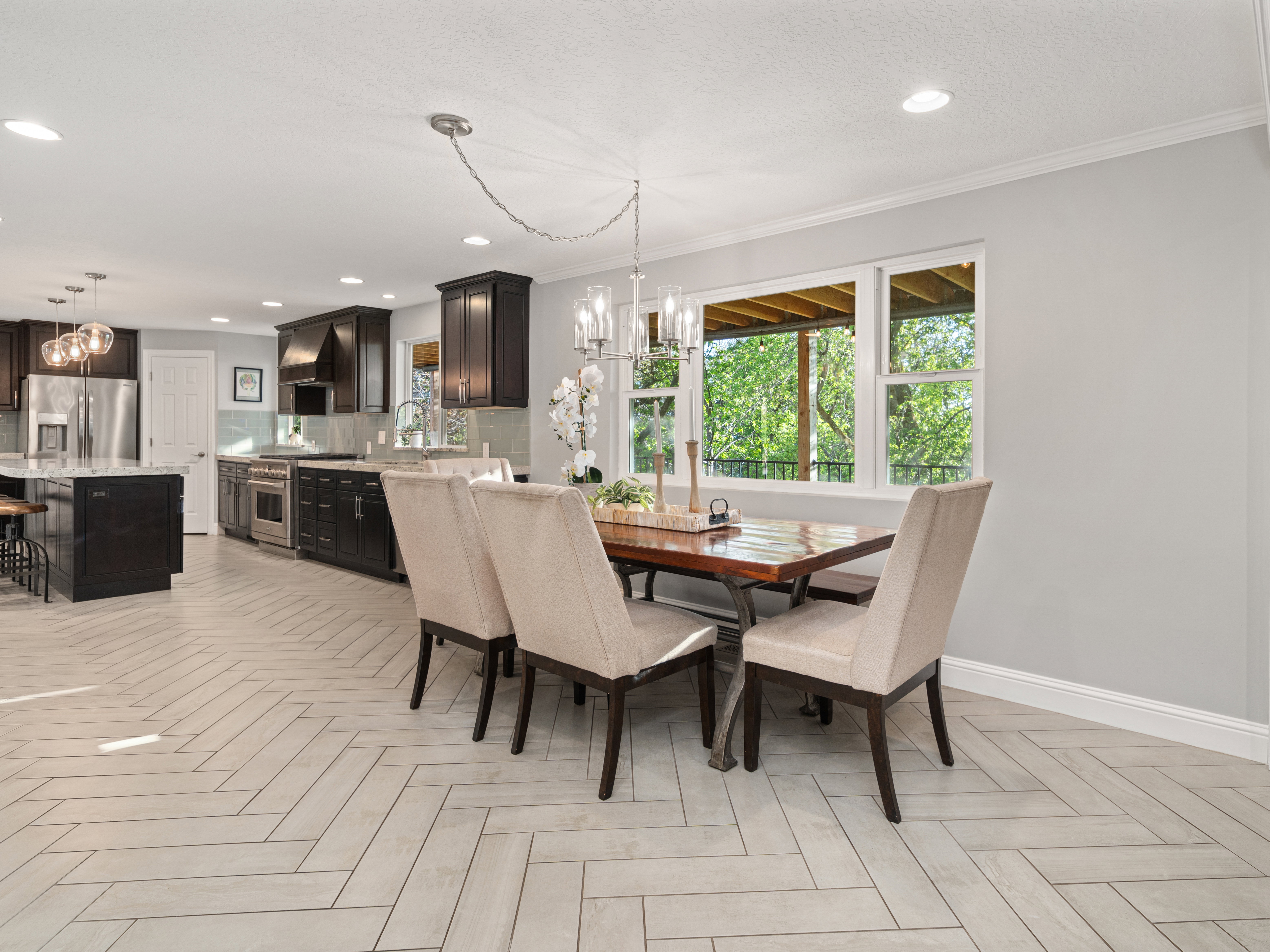 Open-concept kitchen and dining area featuring herringbone-patterned tile flooring