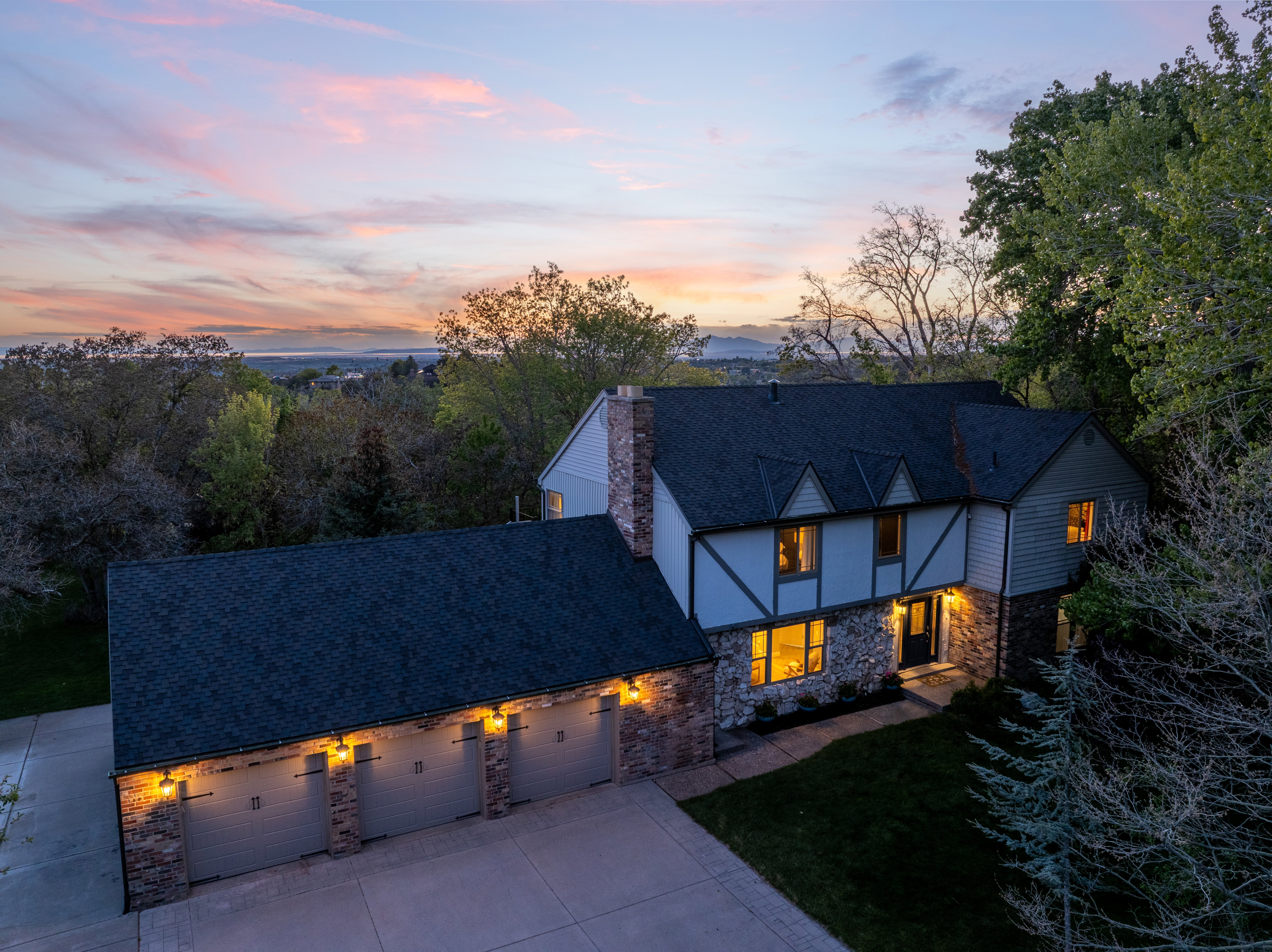 Tudor-style residence featuring stone and siding exterior with dark trim