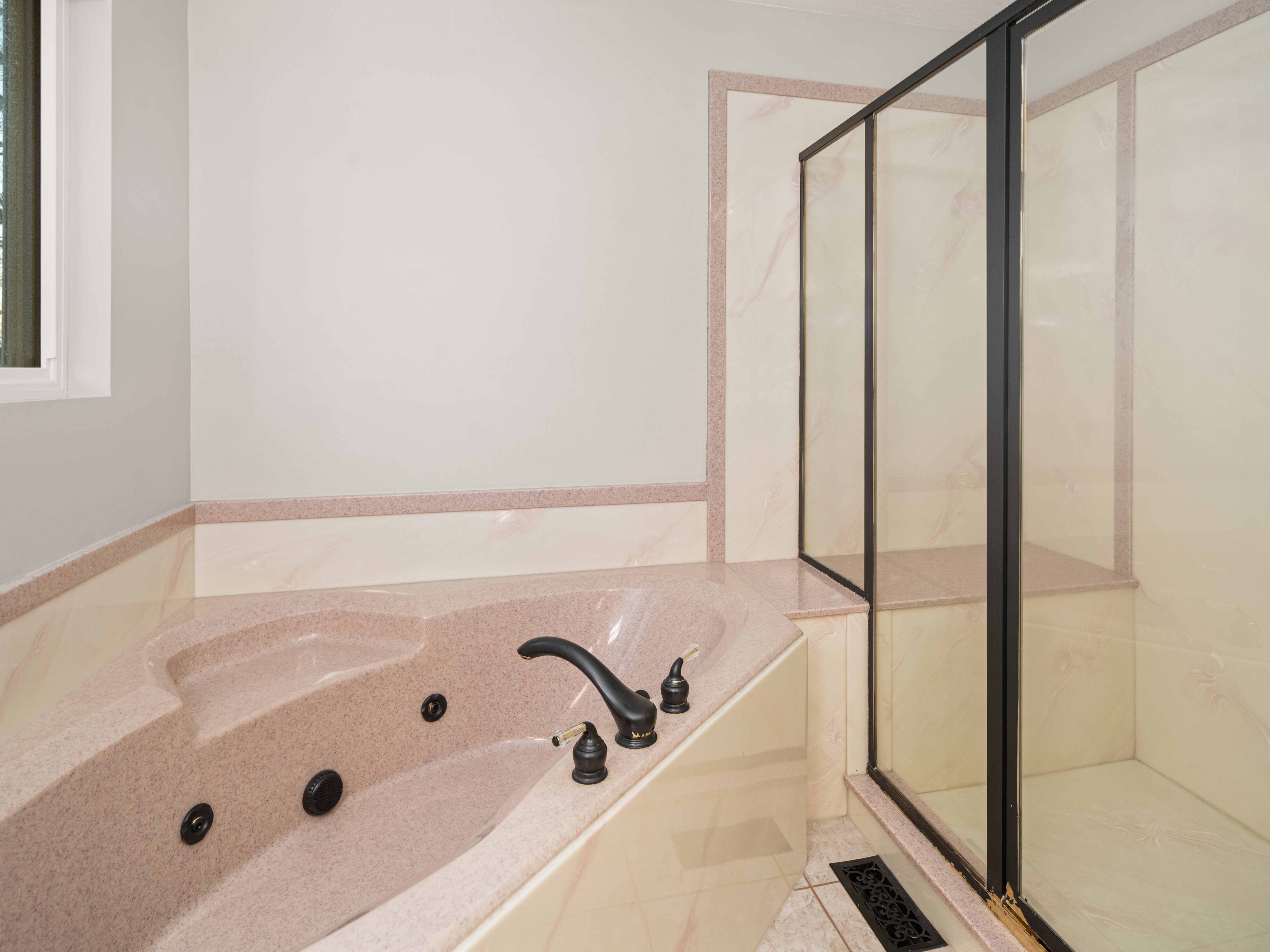 Corner jetted tub with dark bronze fixtures