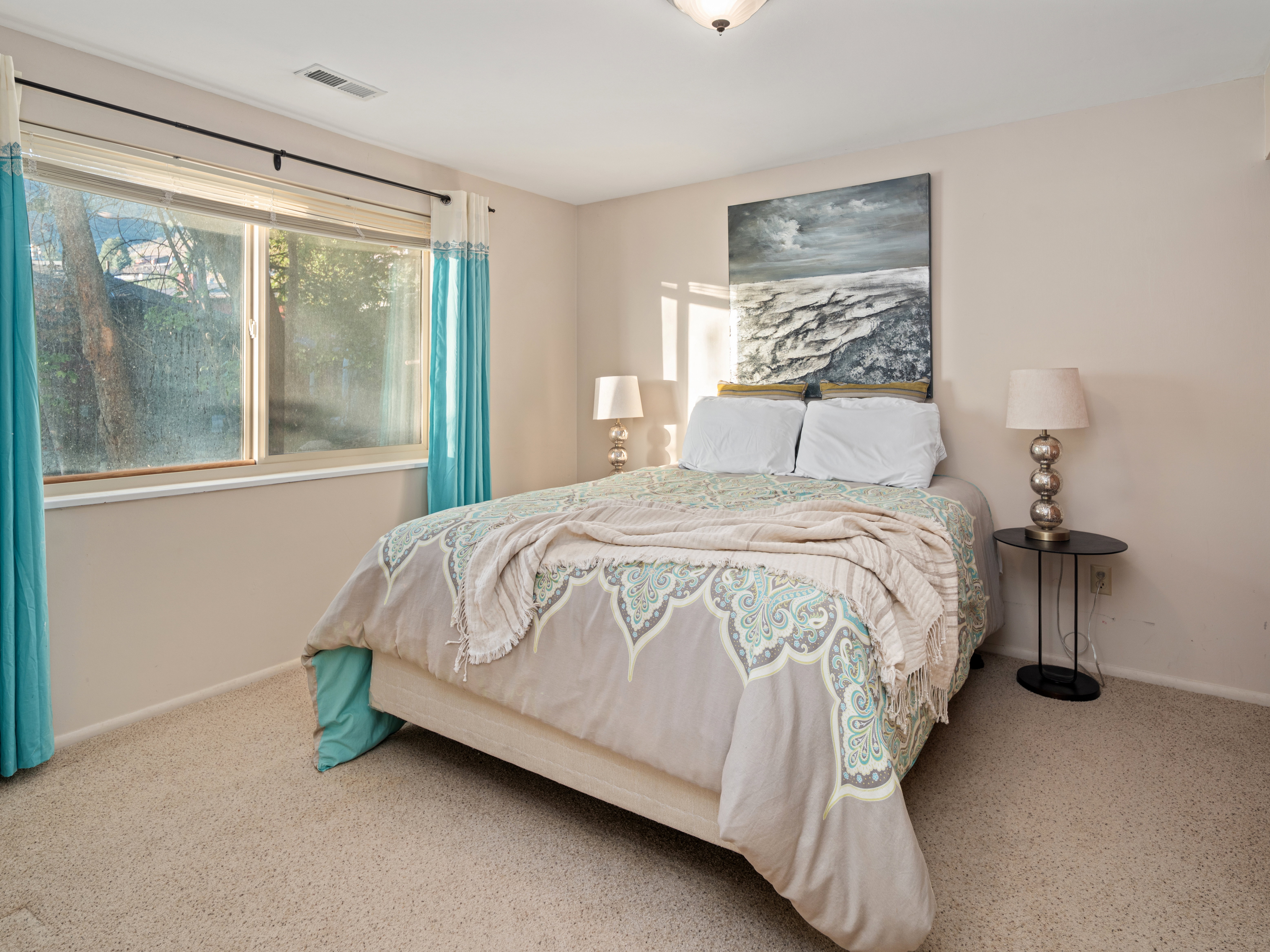 Bedroom featuring a large window, neutral wall paint, and recessed ceiling vent
