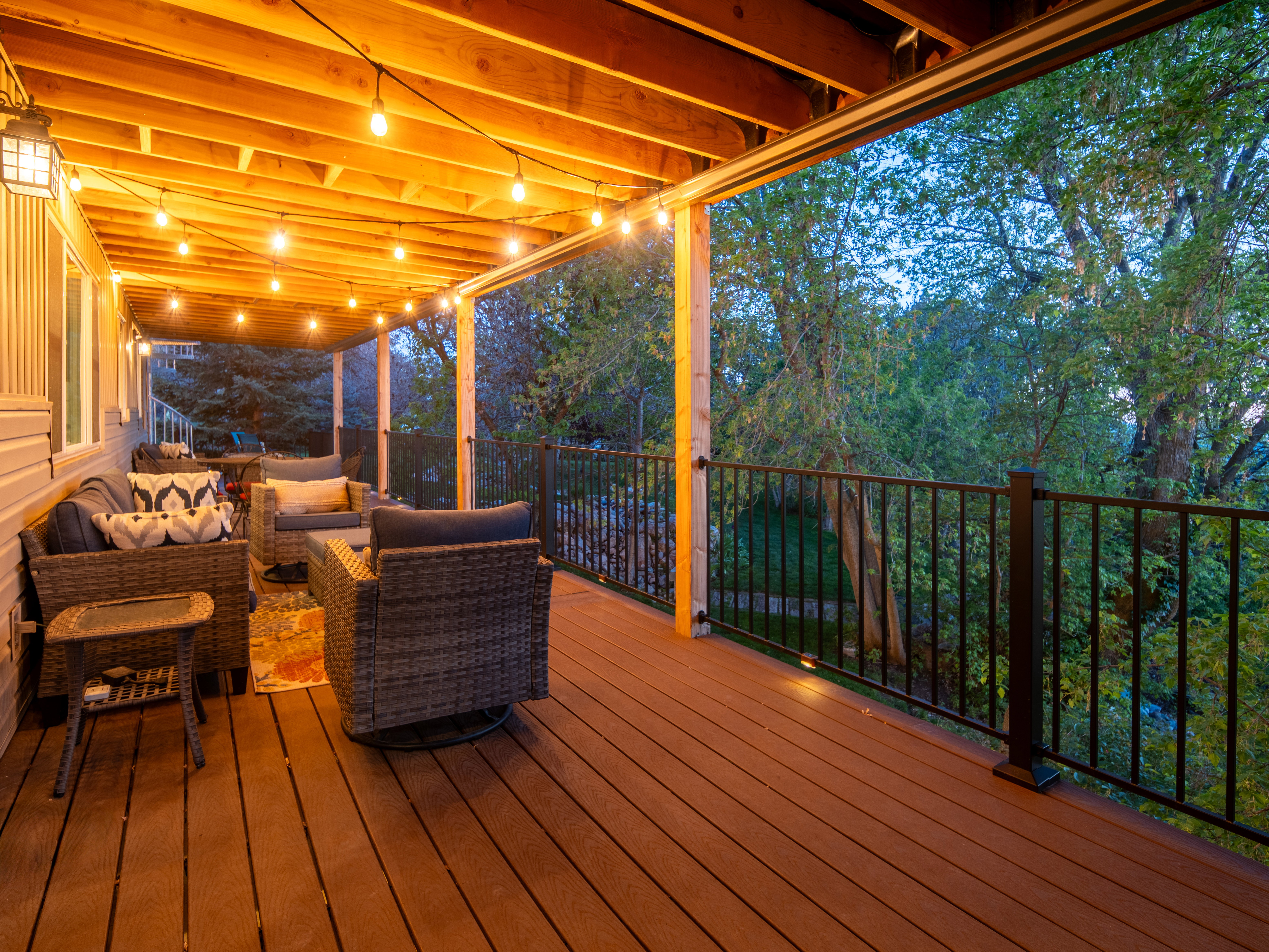 Covered outdoor deck with composite decking and black metal railings