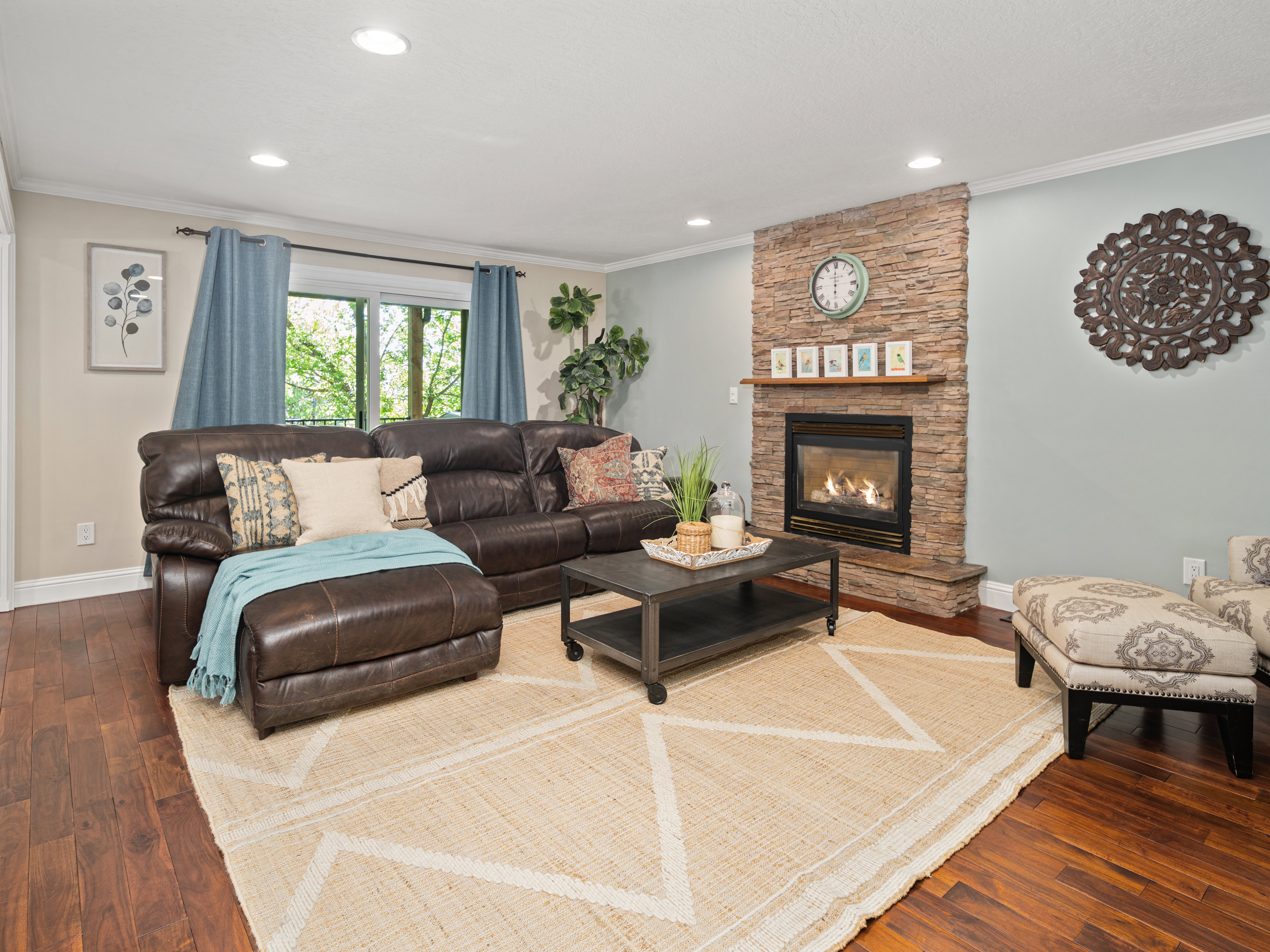 Living area featuring a stacked stone fireplace with a wood mantel