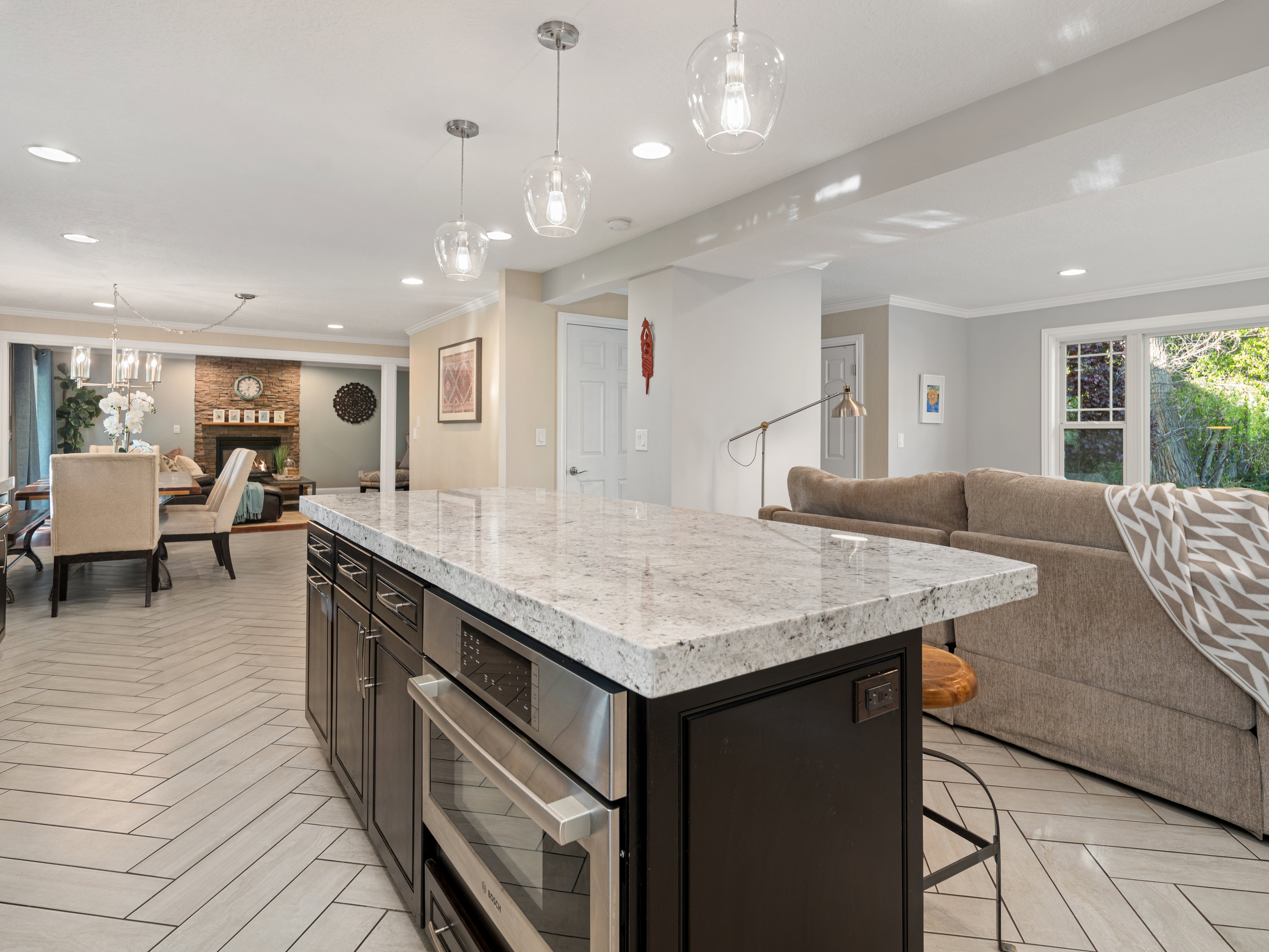 Kitchen island featuring a light-toned stone countertop and stainless steel appliances