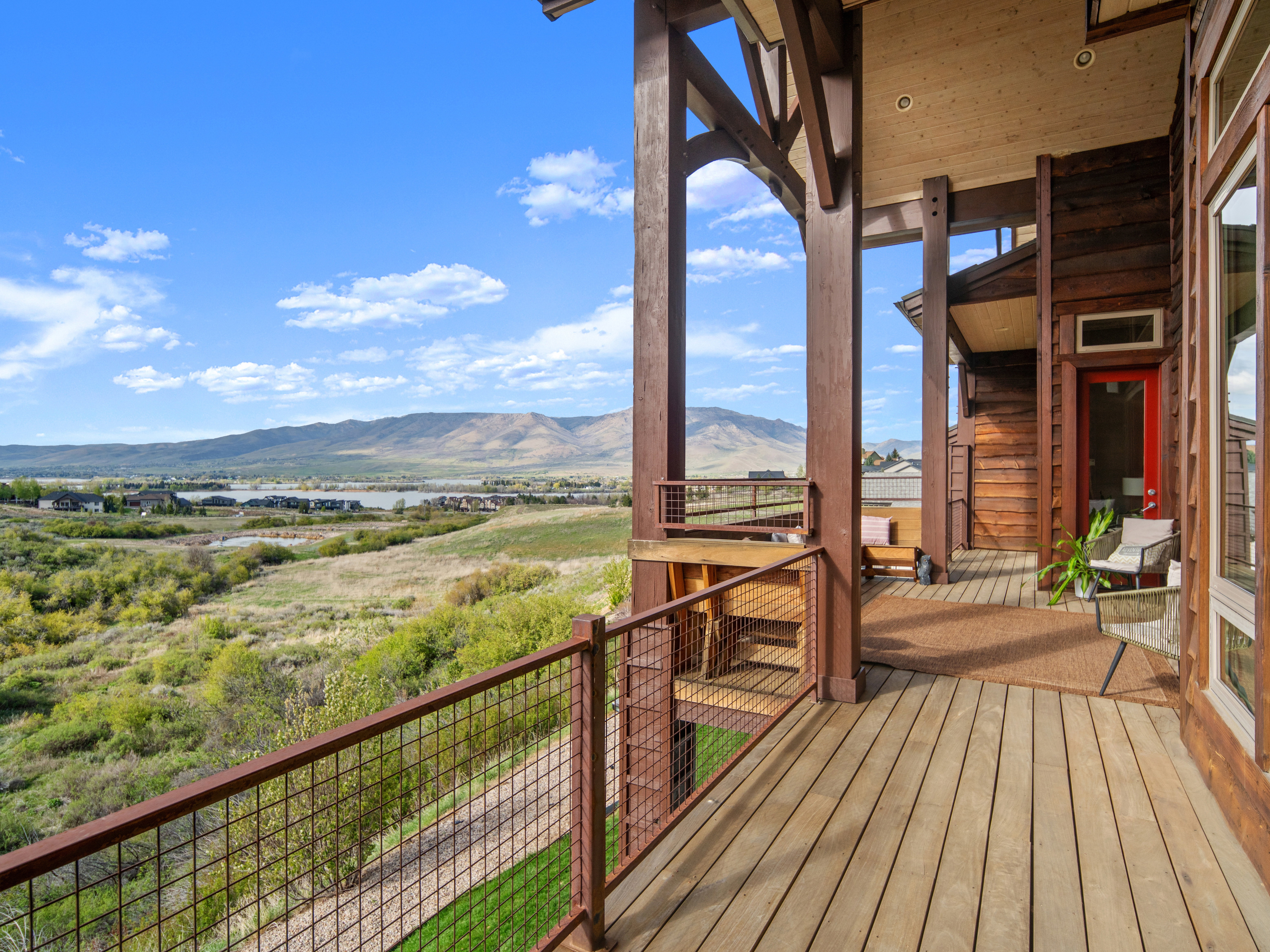 Expansive outdoor decking featuring natural wood planks and a metal grid railing