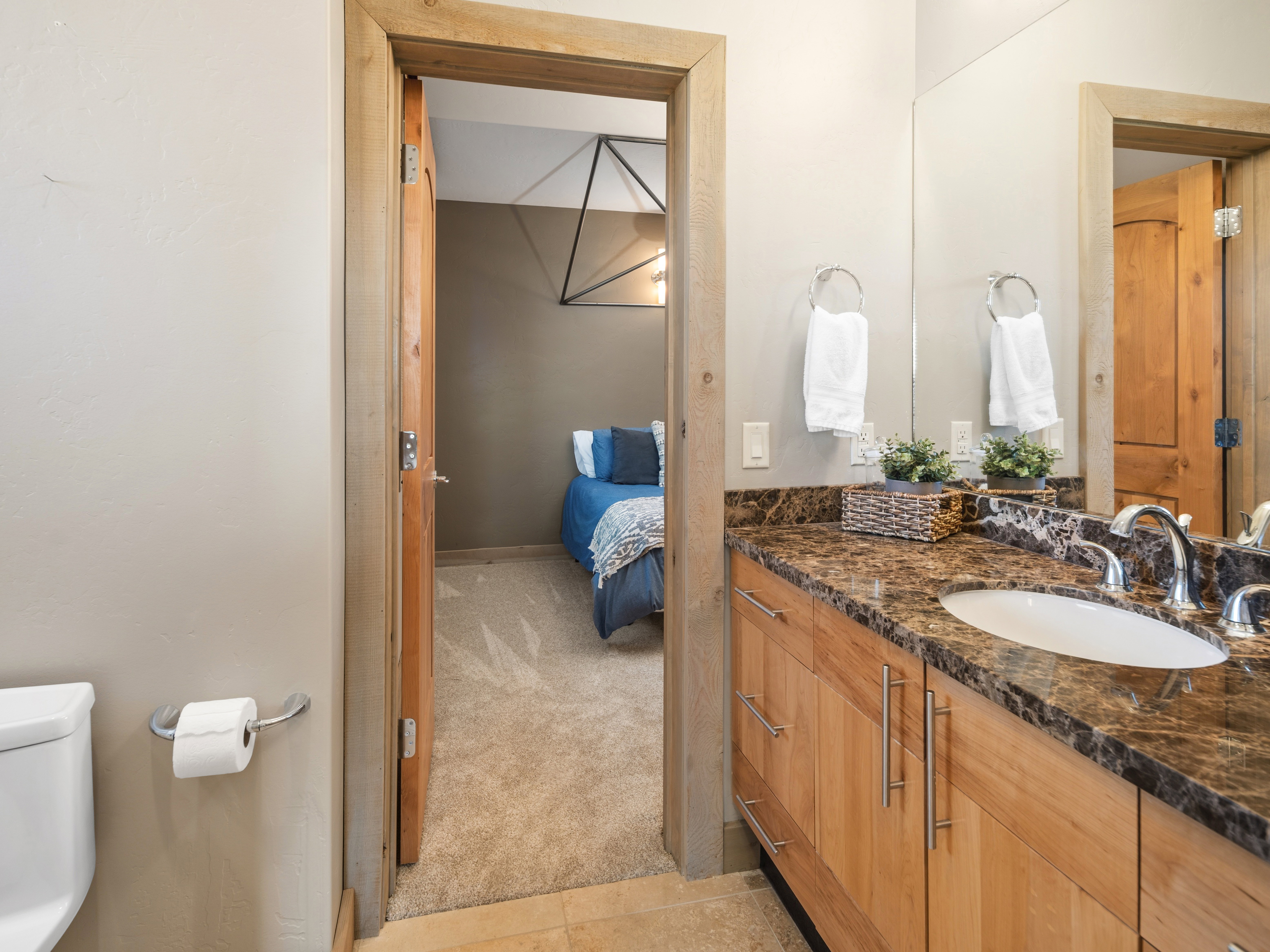 Bathroom vanity featuring a polished stone countertop, undermount sink, and chrome fixtures