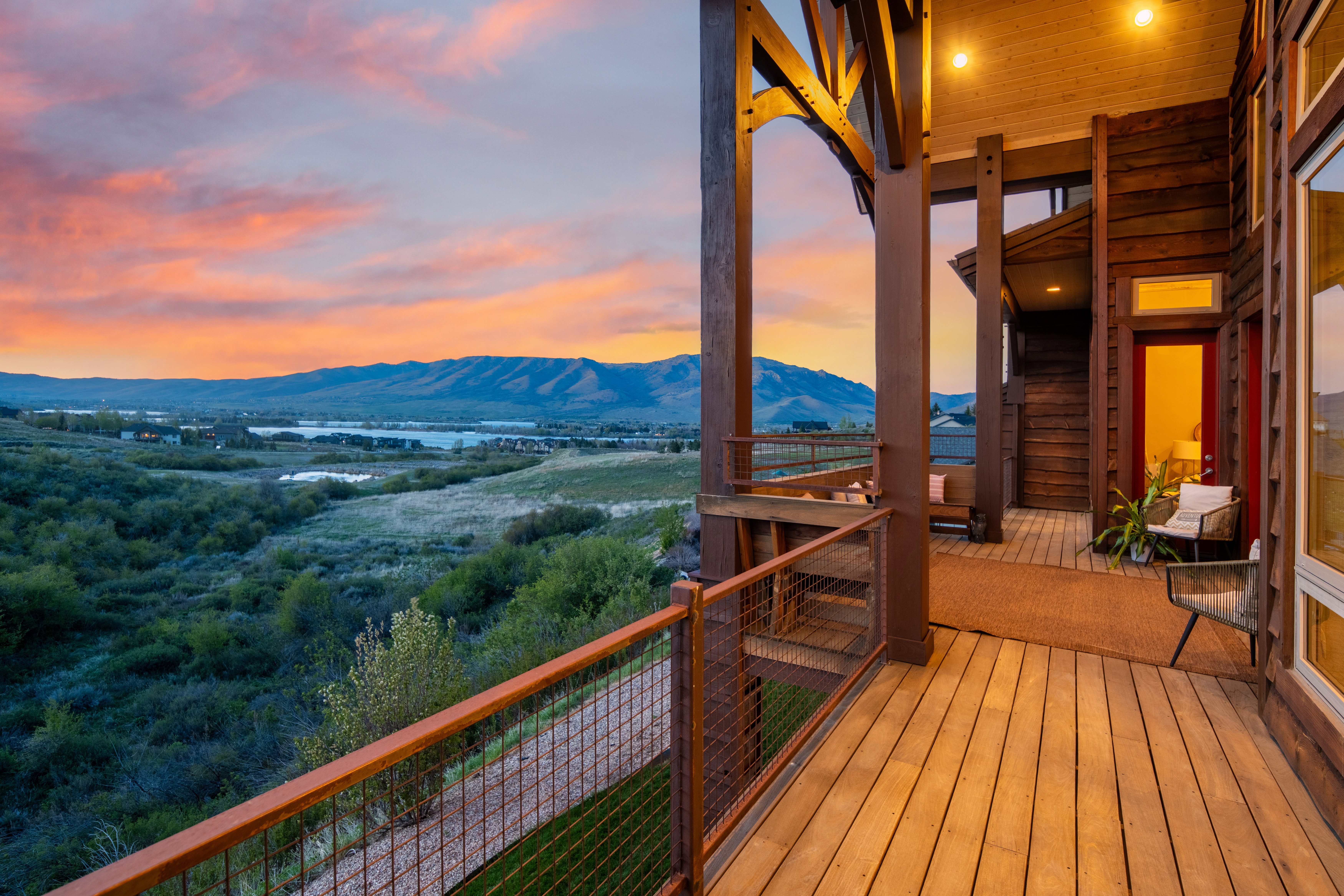 Wood-plank balcony with metal mesh railings, timber frame structural elements, and recessed lighting