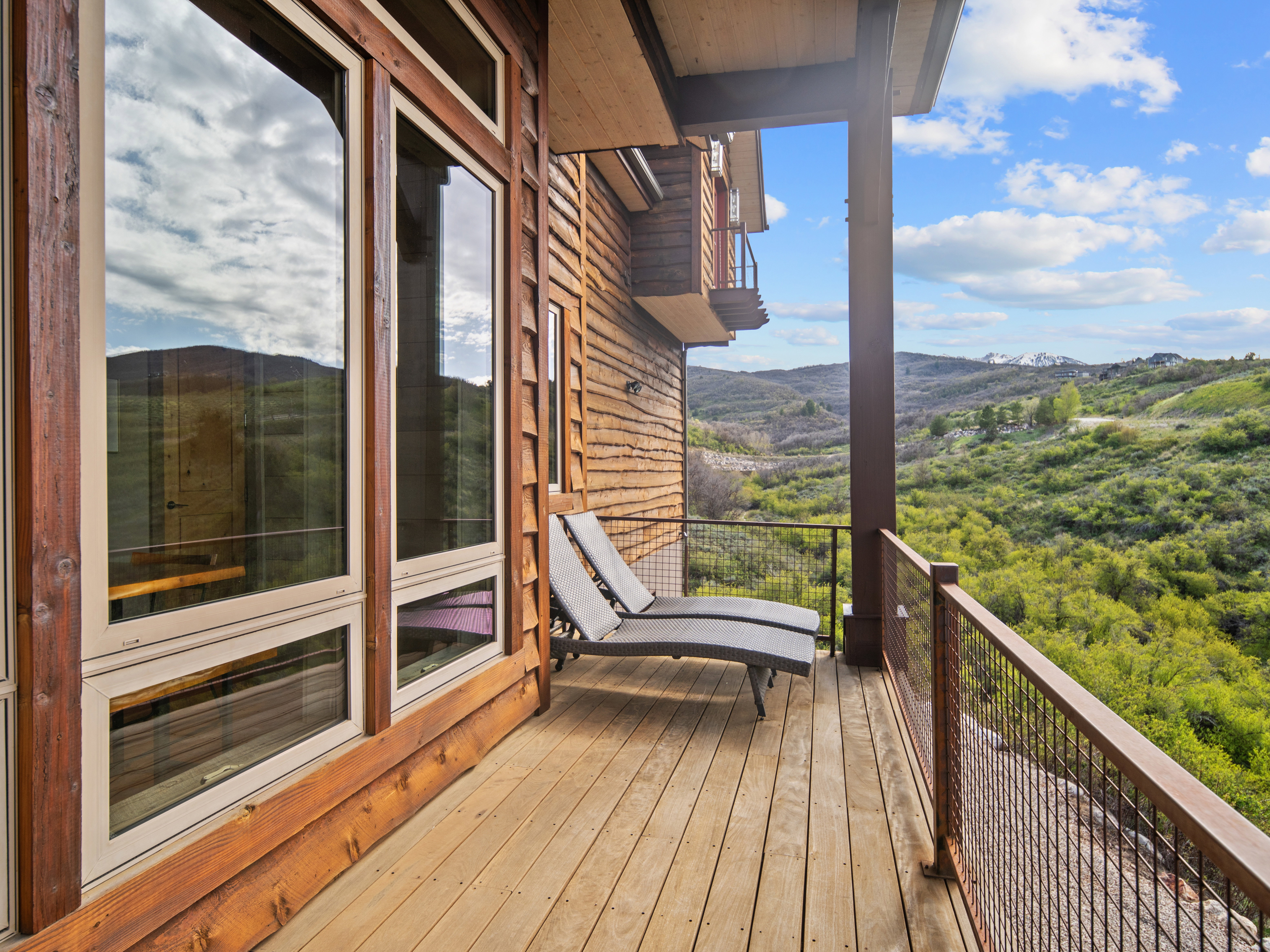 Expansive outdoor deck featuring wood flooring and metal railings