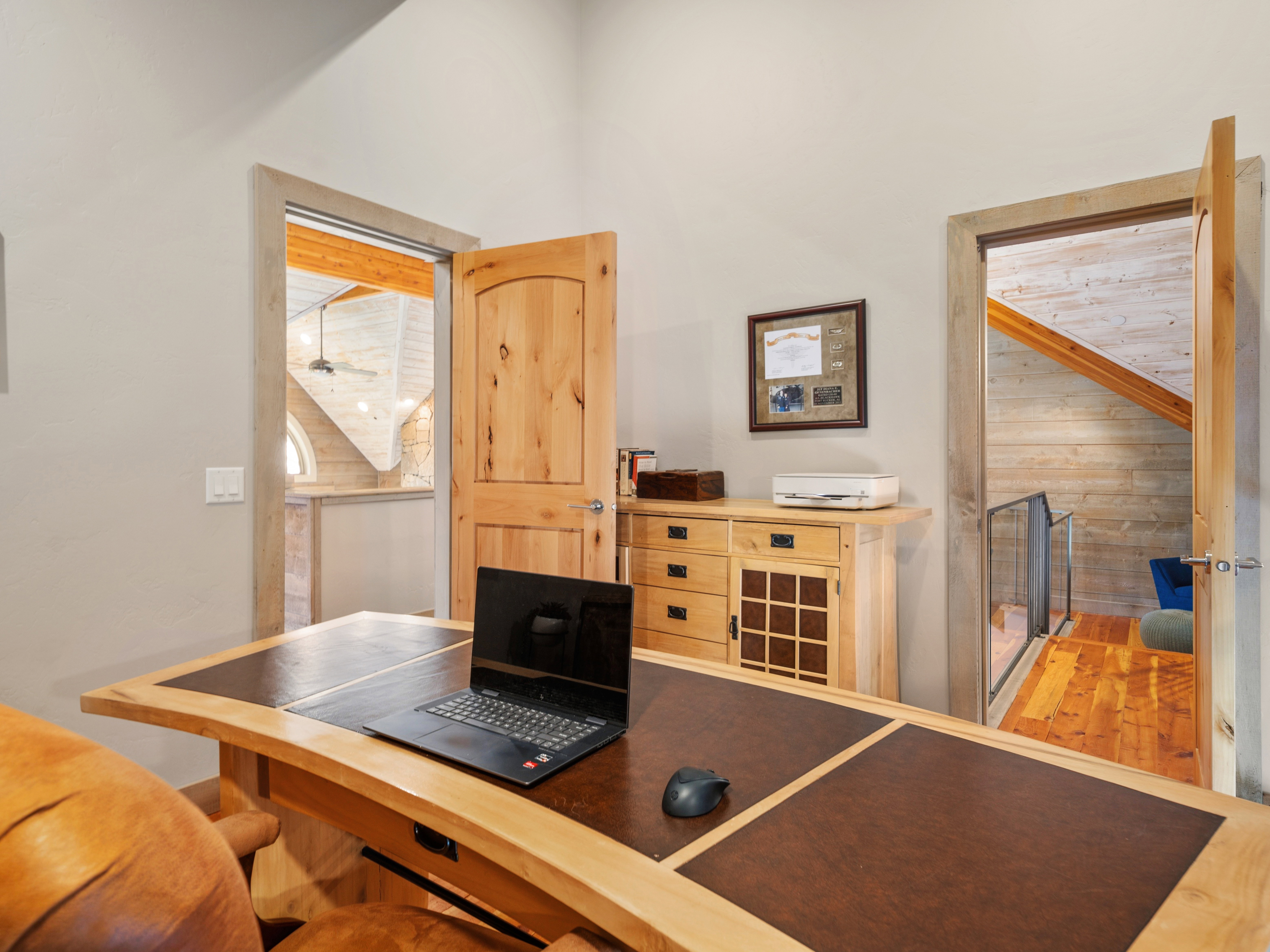 Dedicated office space featuring natural wood doors and trim, light-toned walls, and a built-in wooden cabinet with drawers and a grid-patterned door